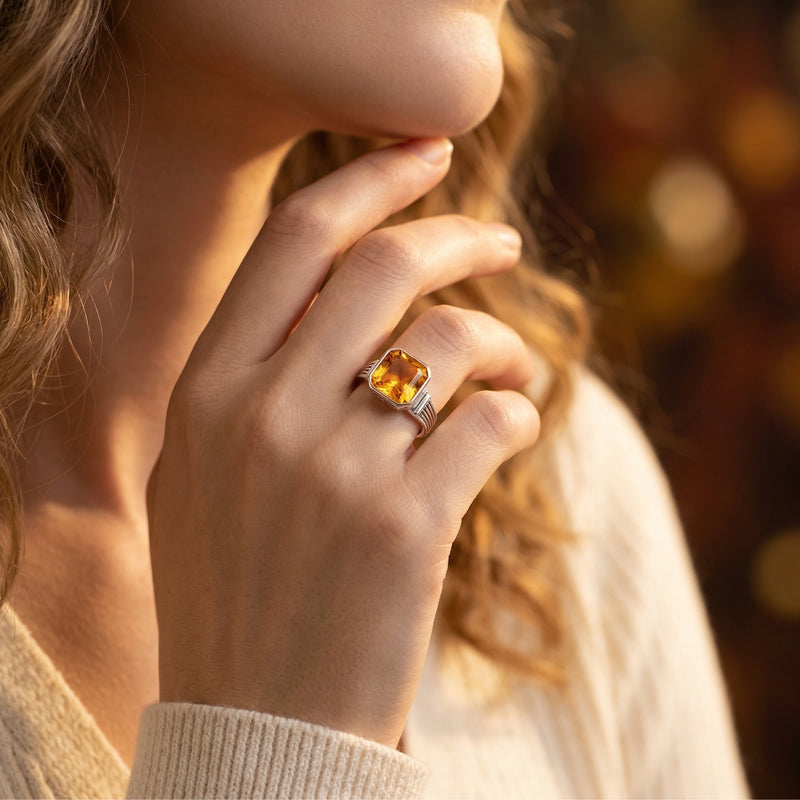 Woman's hand wearing the Asscher cut natural citrine ring in sterling silver.
