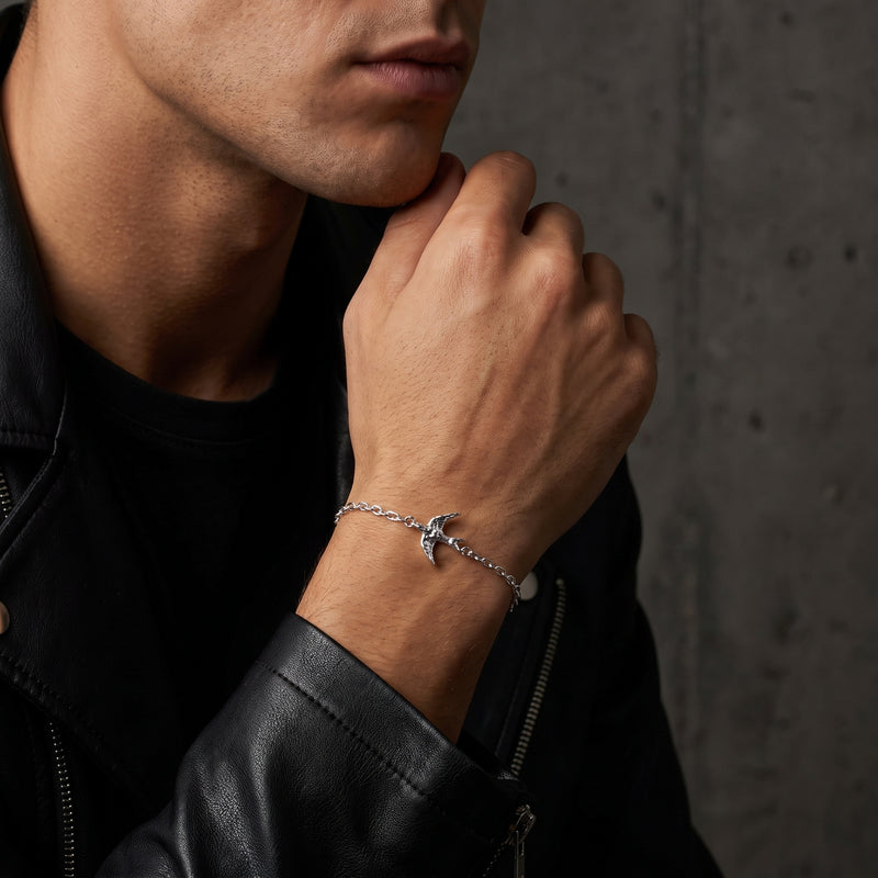 Close-up of a man wearing the silver swallow bracelet with a black leather jacket.