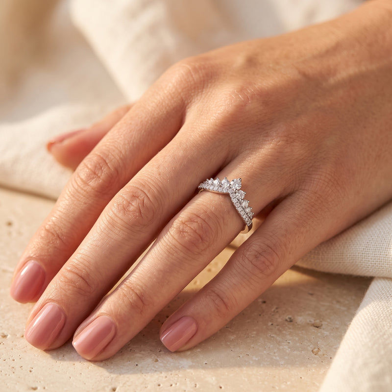 Double-row silver chevron ring with cascading cubic zirconia worn on a woman's hand.