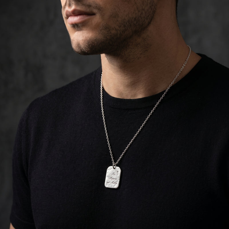 Model wearing the silver star tag pendant necklace over a black T-shirt, showing its drape on the chest.