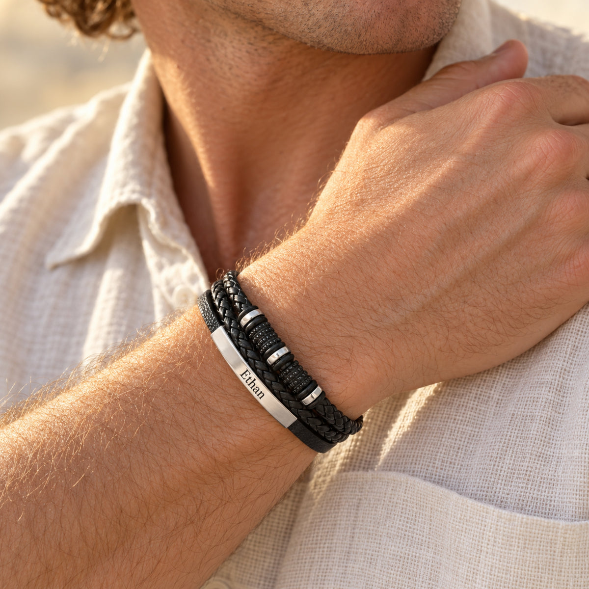 Black multi-strand Next Chapter bracelet worn on a wrist, with example Ethan nameplate