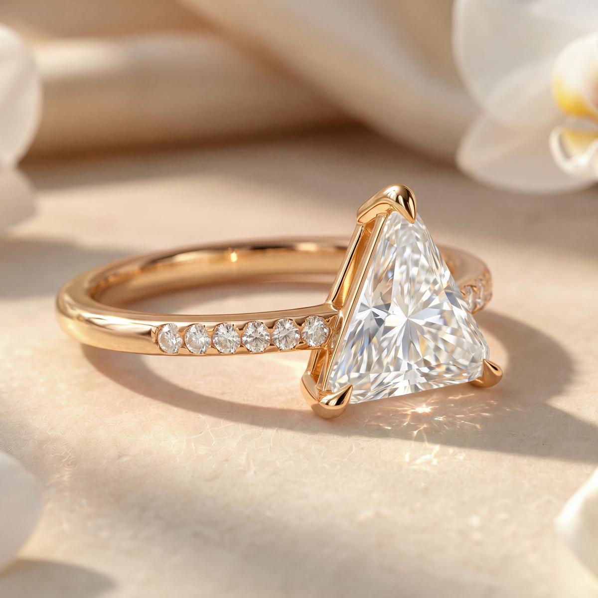 Side view detail of the yellow gold triangle-cut moissanite ring showing the basket setting and pavé band.