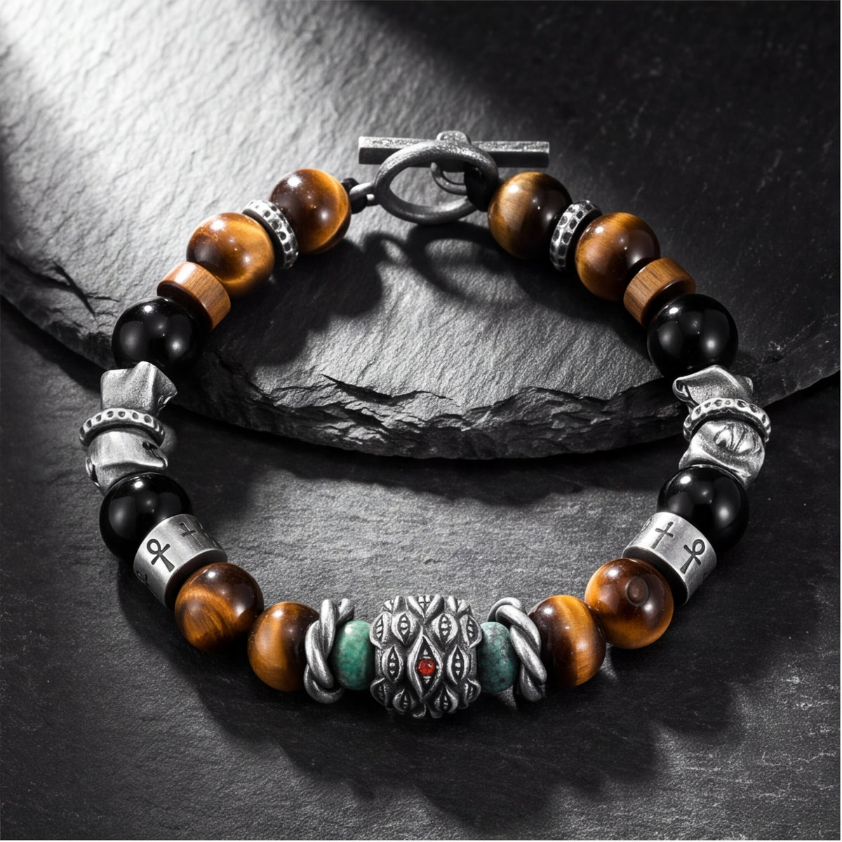 Overhead view of the silver beaded bracelet laid flat in a ring, showing the central eye charm and toggle clasp.