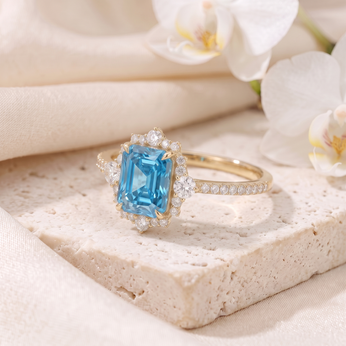 Side-angled view of an emerald cut blue moissanite halo ring in yellow gold.