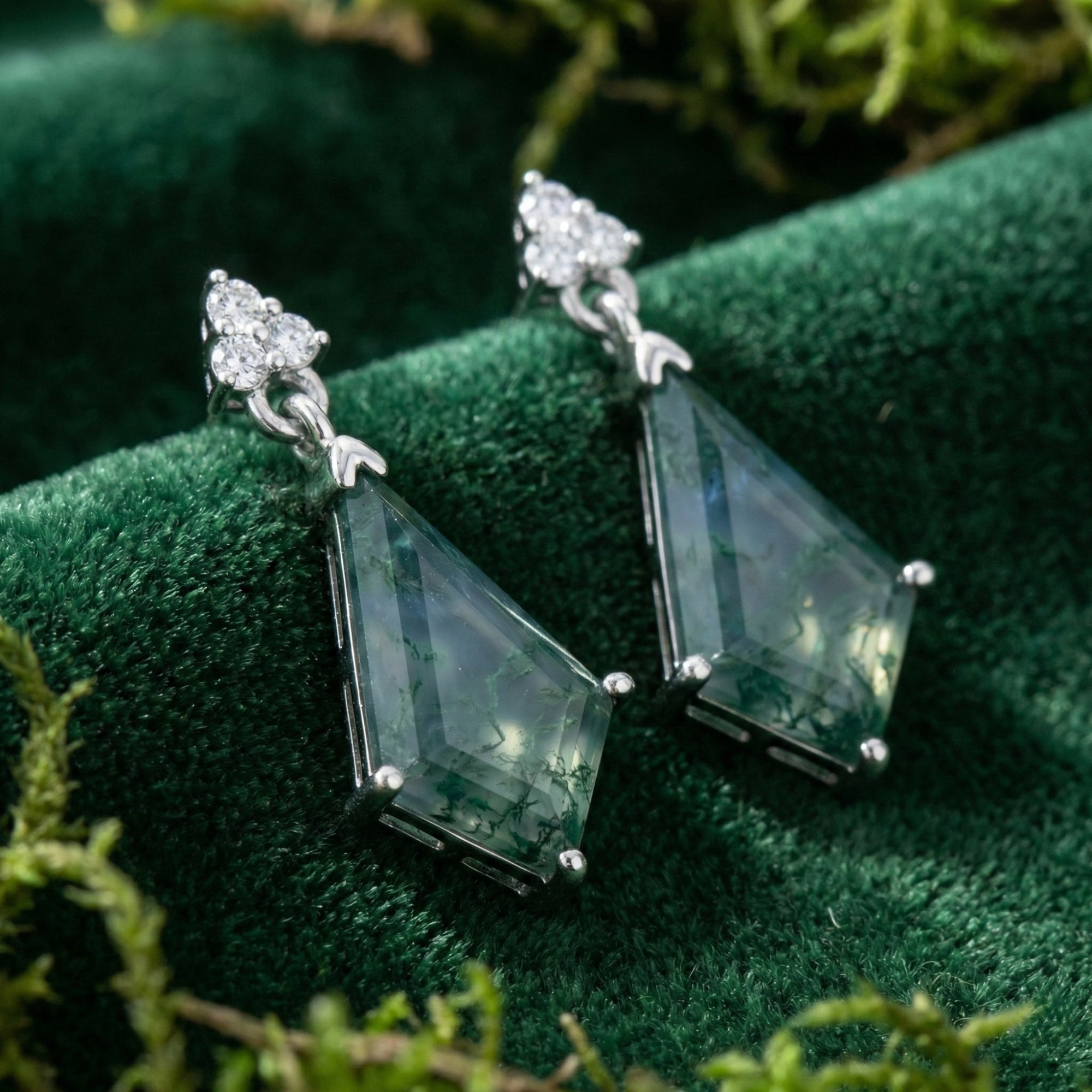 Macro shot of kite cut moss agate drop earrings in sterling silver, showing the intricate green stone patterns.