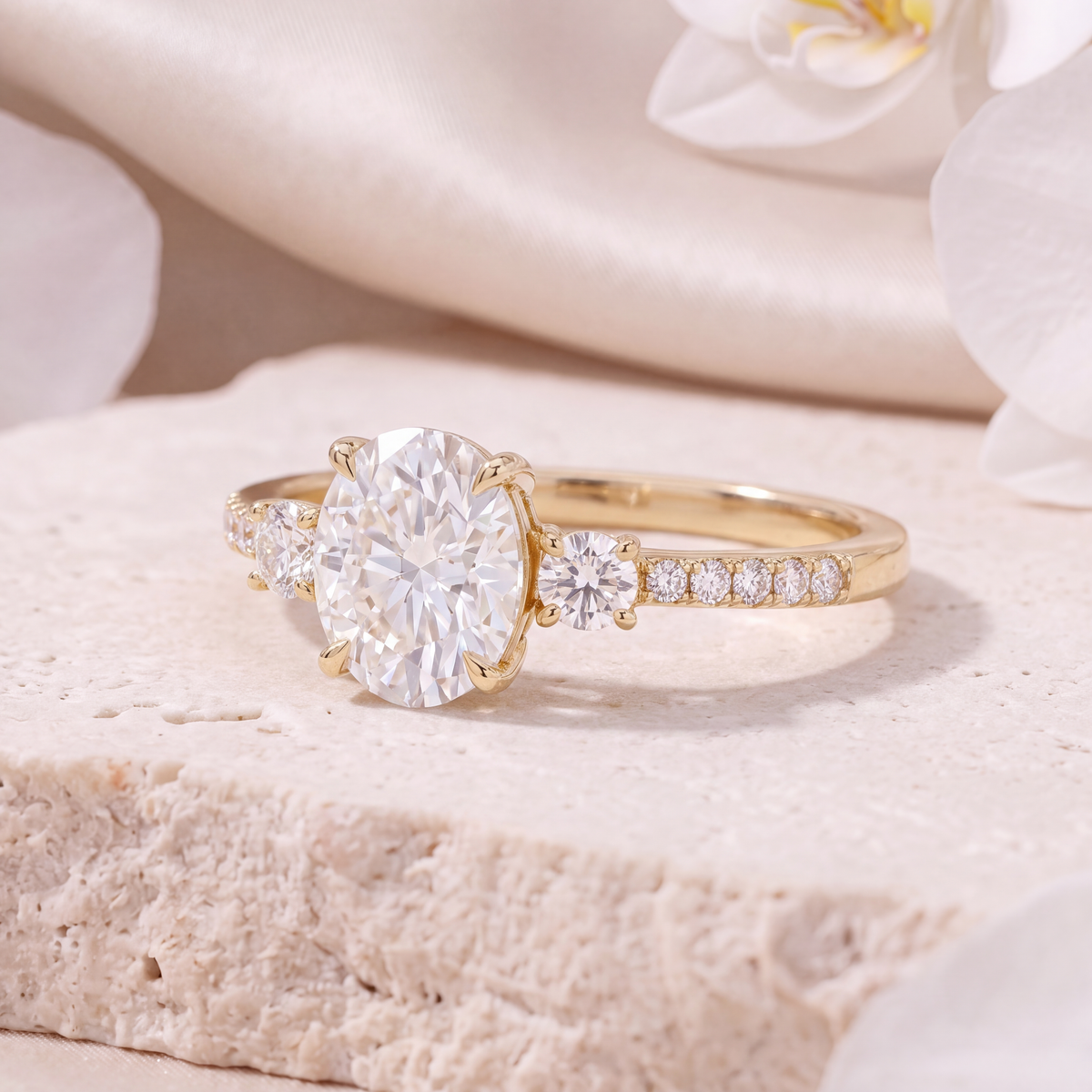Angled view highlighting the setting and side stones of the yellow gold oval moissanite ring.