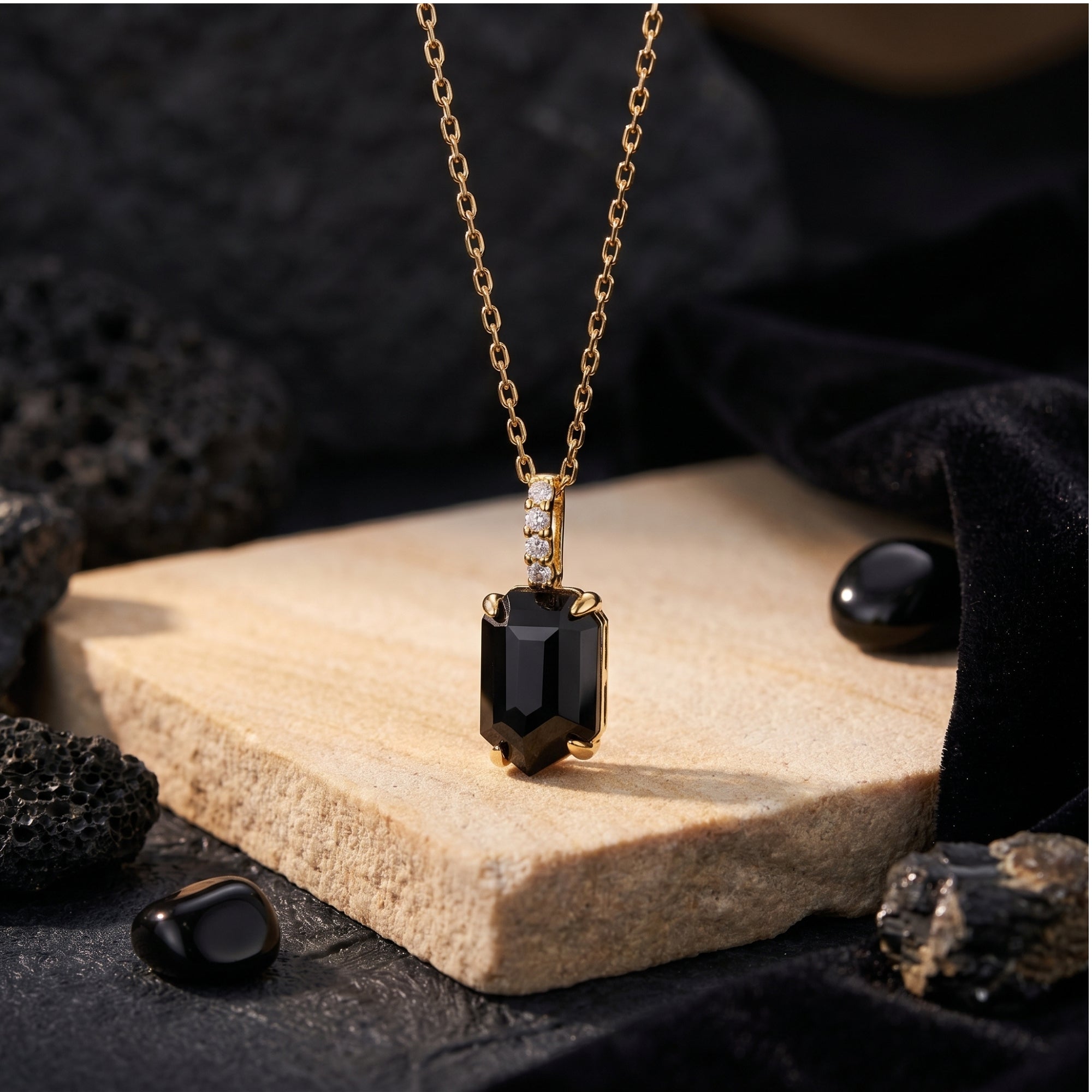 Detail view of the faceted square-cut black onyx pendant and 18K gold plated bail with stone accents.