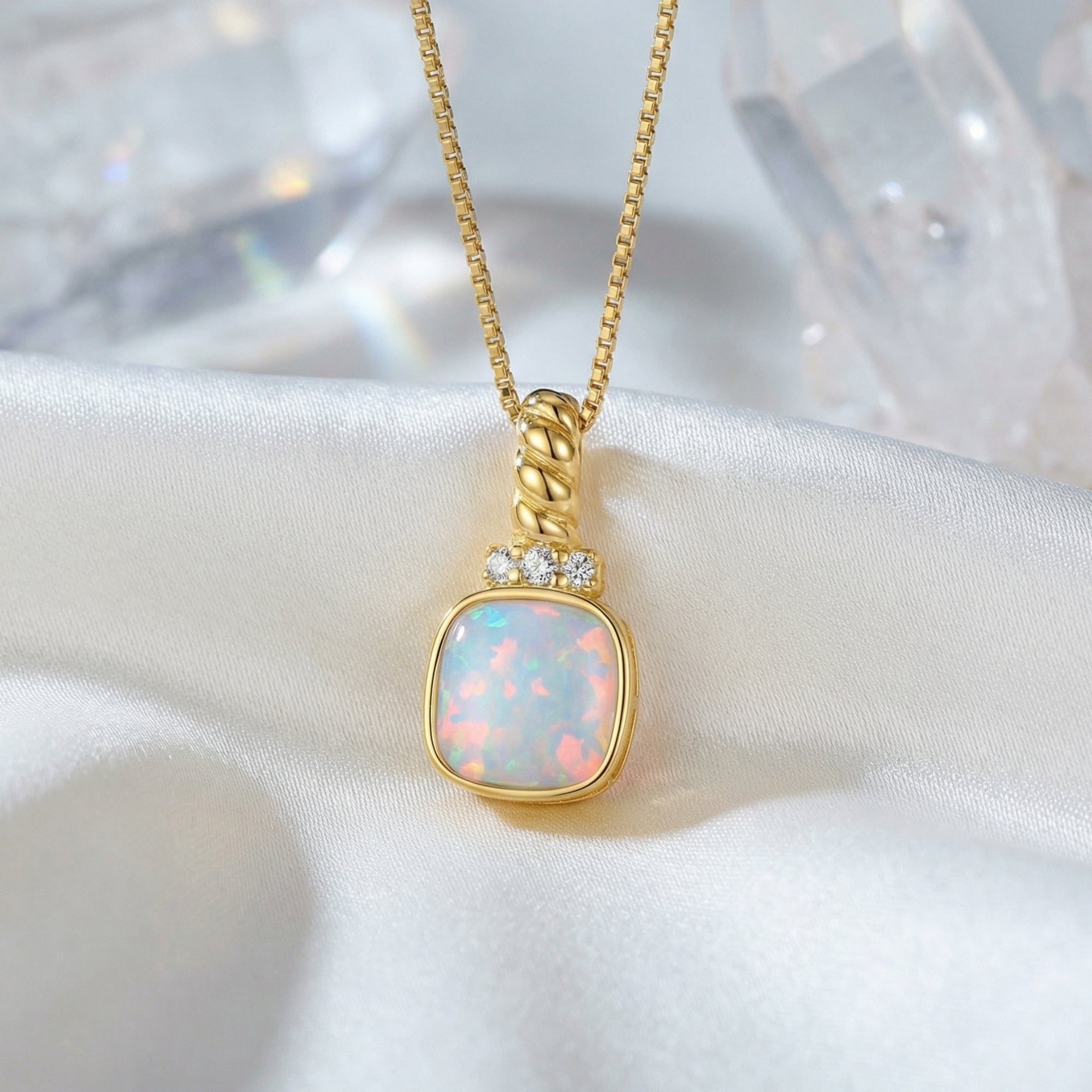 Close-up of the cushion-cut white opal pendant with gold-tone sunburst setting and accent stones.
