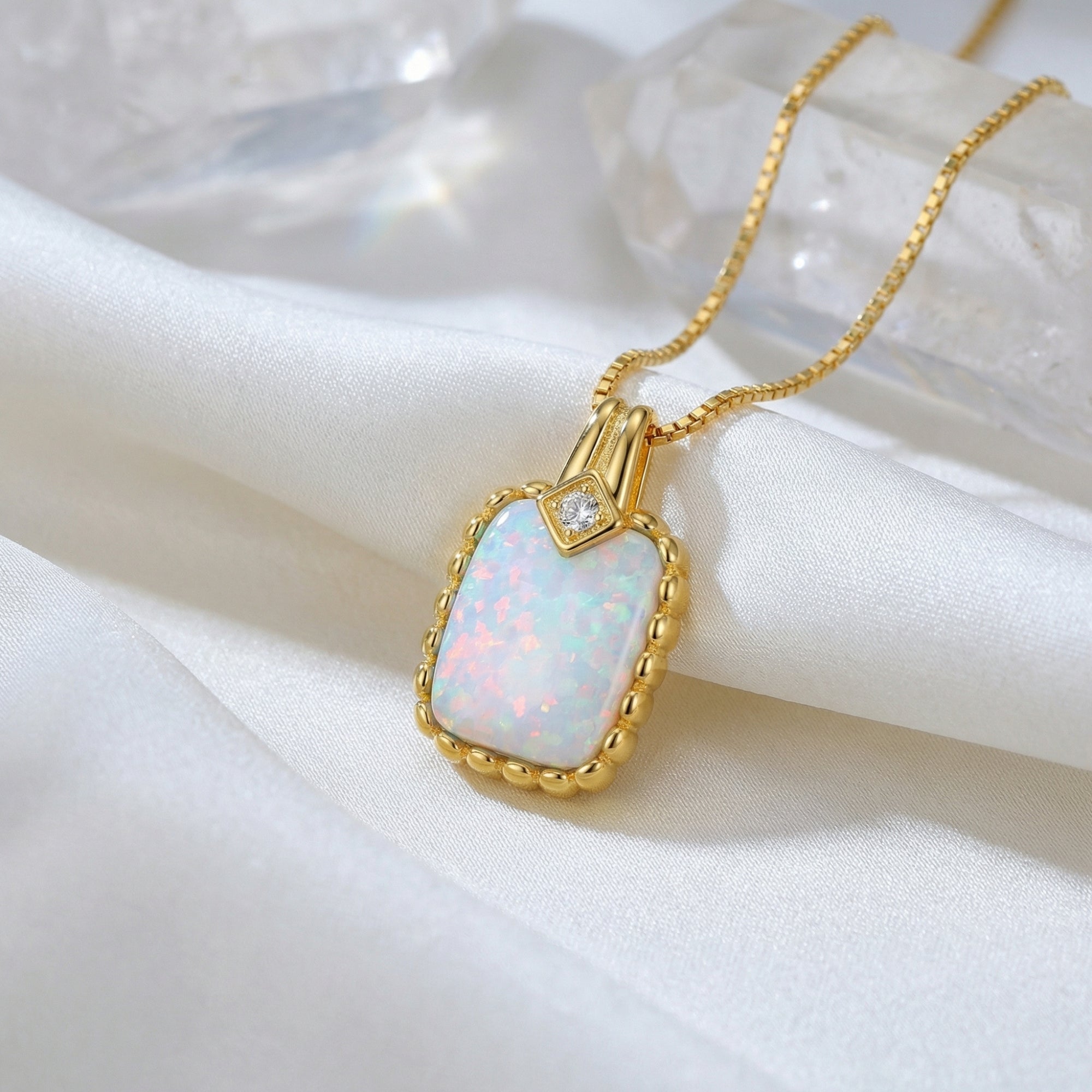 Close-up of a gold vermeil cushion cut white opal pendant showing the iridescent play-of-color.