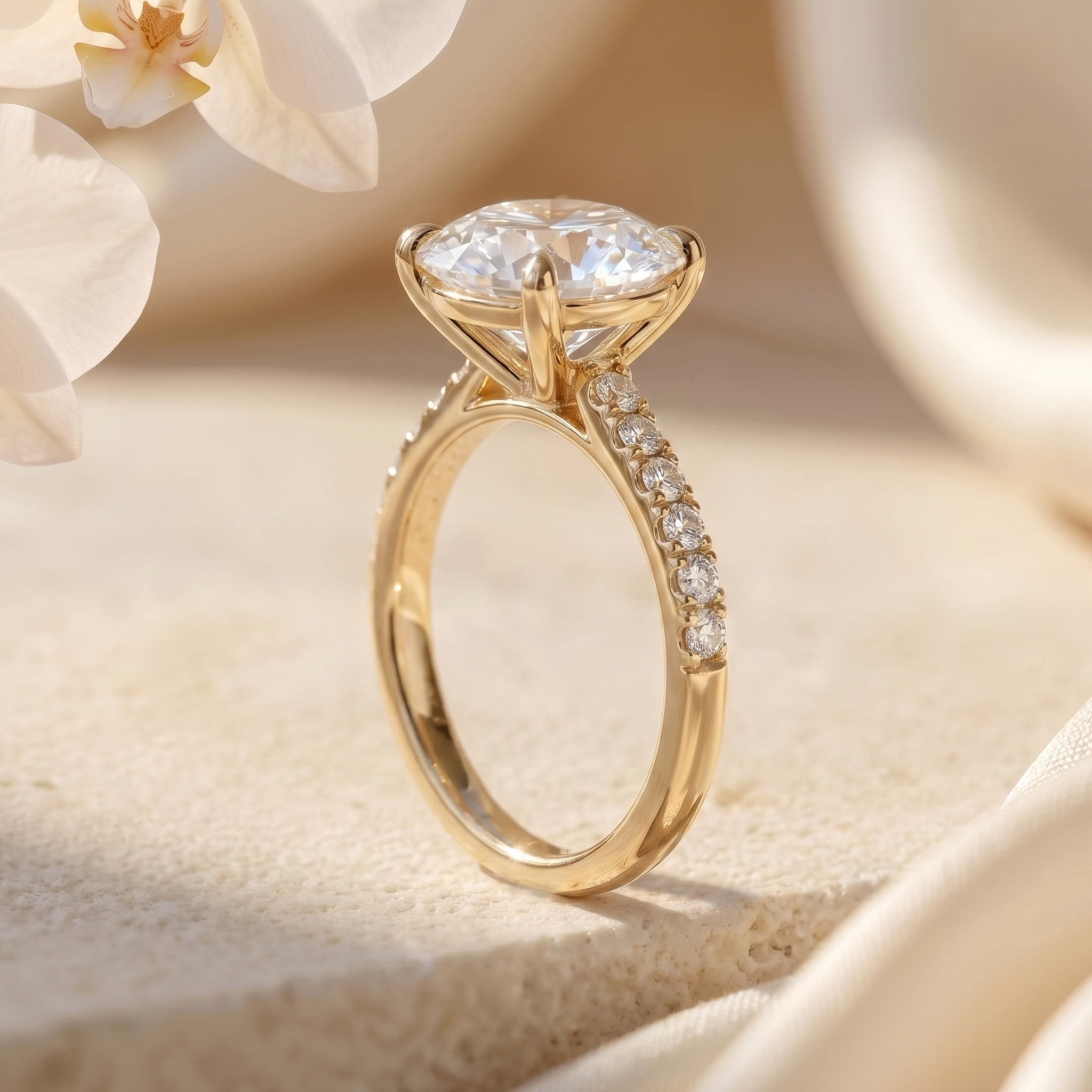 Profile view of a yellow gold round cut moissanite engagement ring with a pavé band, showing the prong setting.