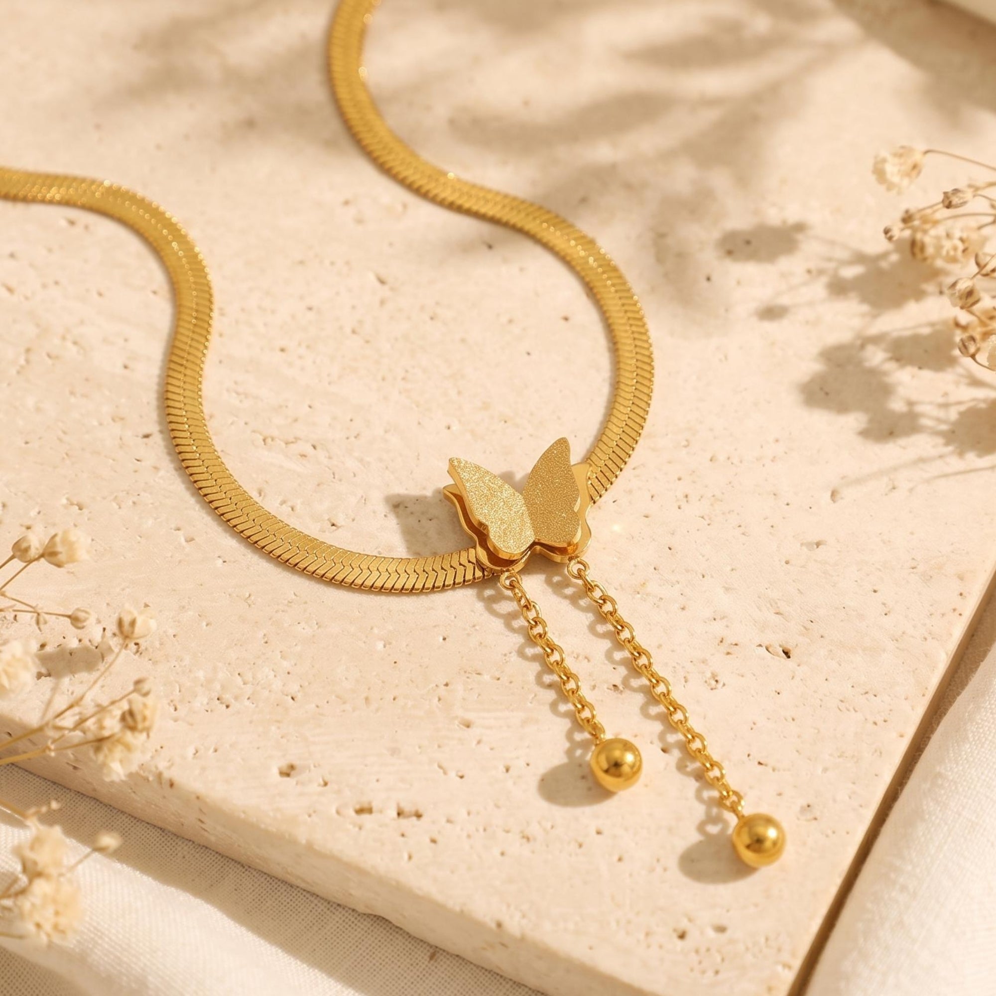 Le collier à pampilles et pendentif papillon
