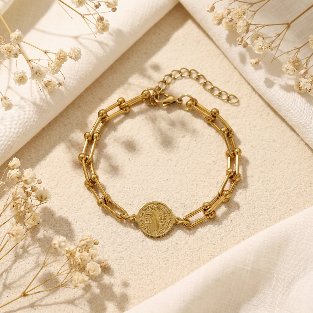 Overhead view of the gold-tone Saint Benedict link bracelet laid flat, with its clasp and extender chain visible.