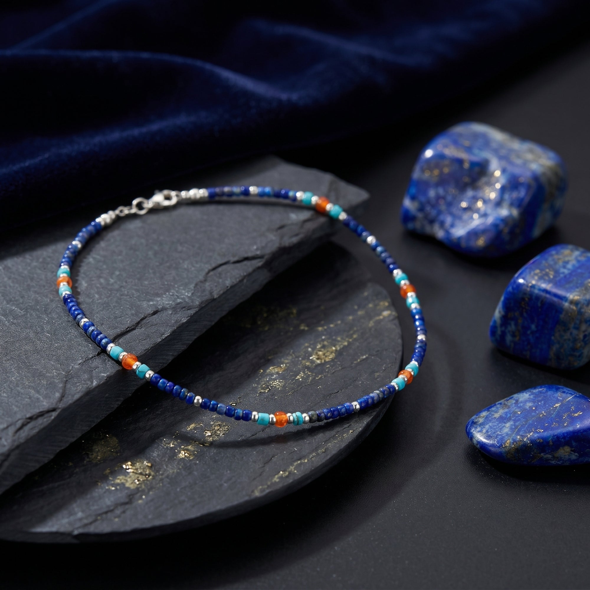 Beaded 5mm lapis, turquoise, and orange necklace with silver-toned spacers and clasp on a slate surface.