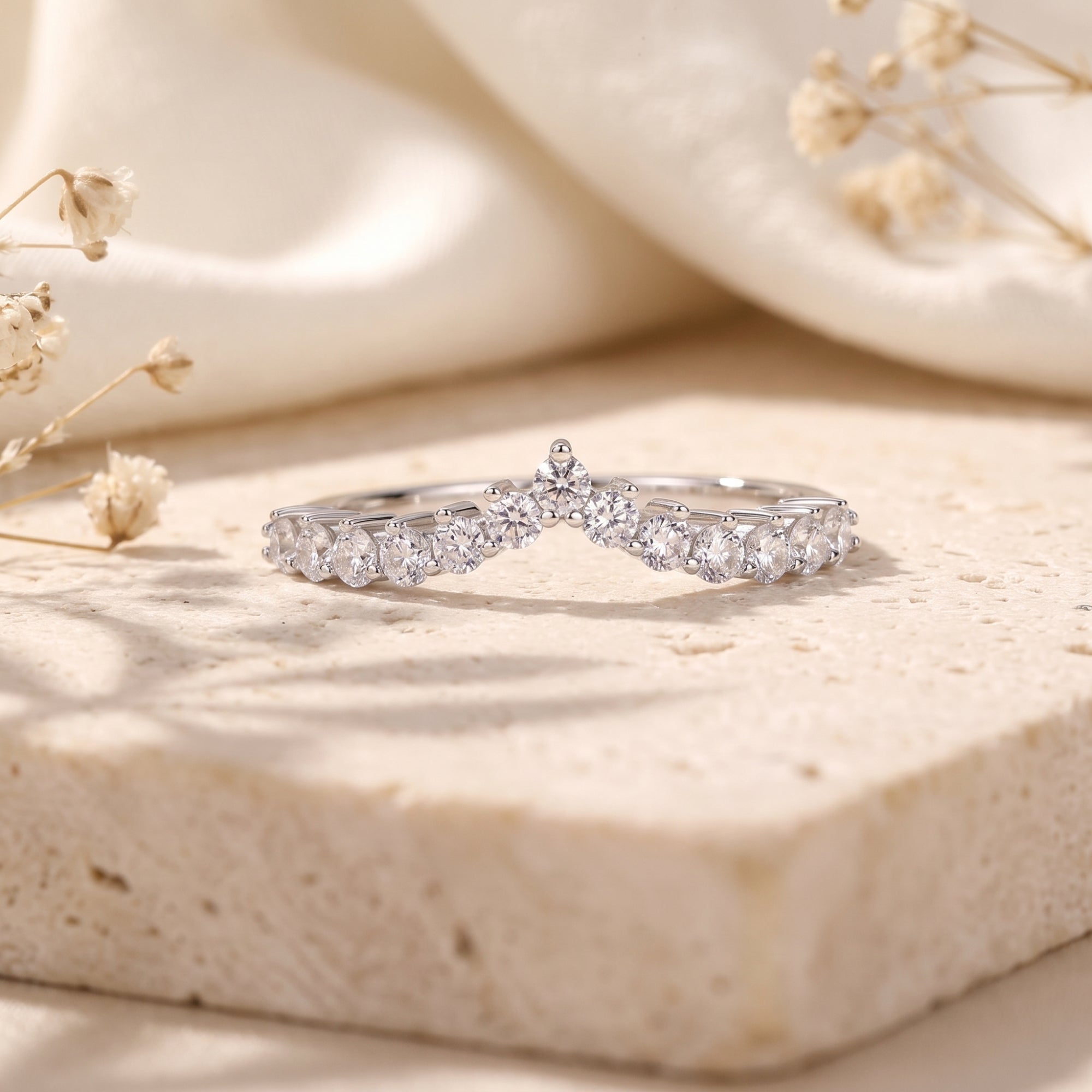 Close-up of a silver chevron ring featuring round-cut cubic zirconia stones.