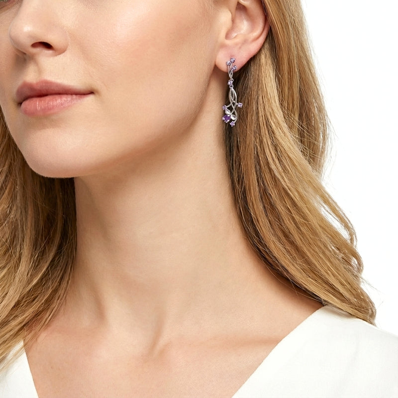 Side view of a model wearing a sterling silver Lyriel drop earring with royal purple simulated amethyst.