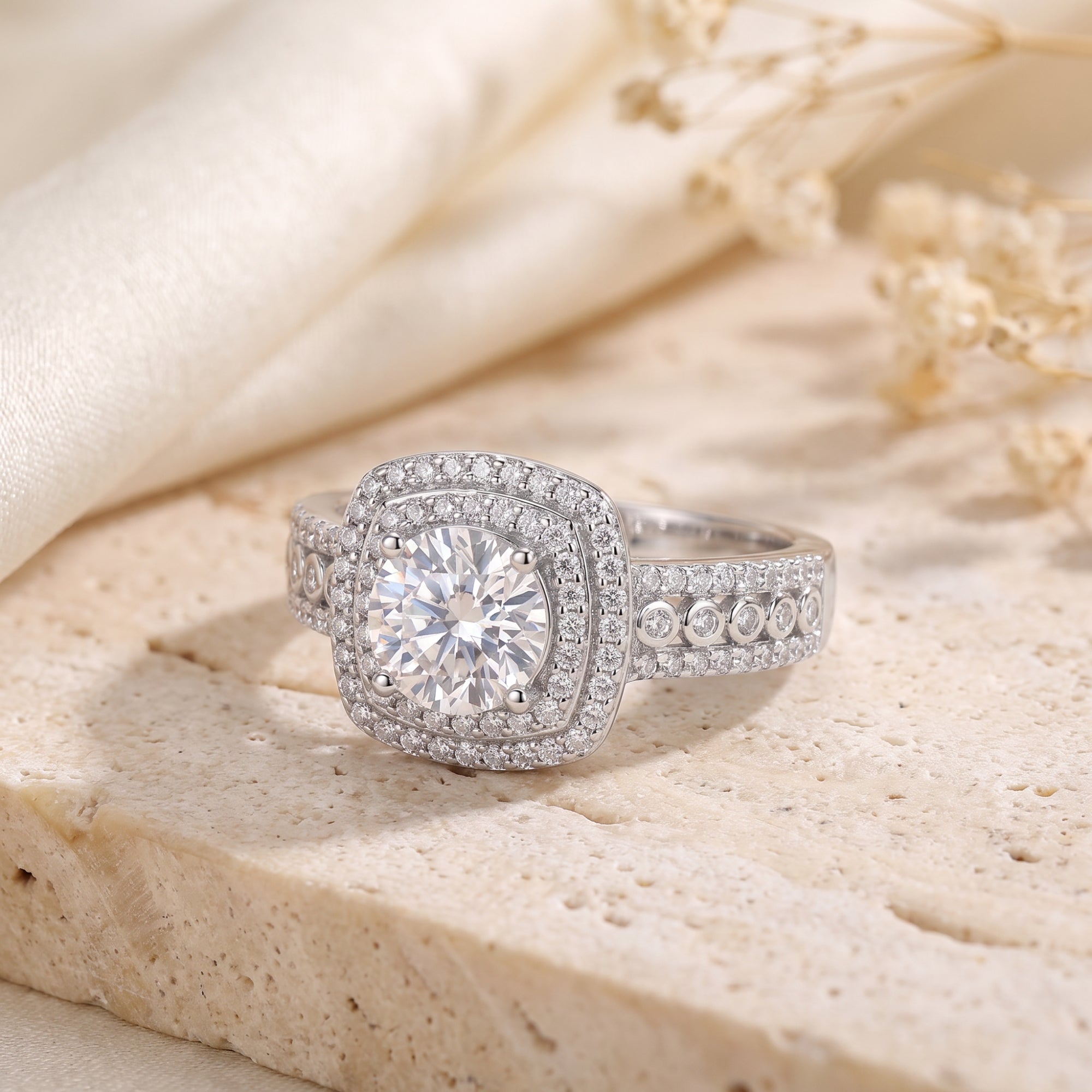 Macro view of a silver cushion double halo ring highlighting the round brilliant stone and pavé setting.