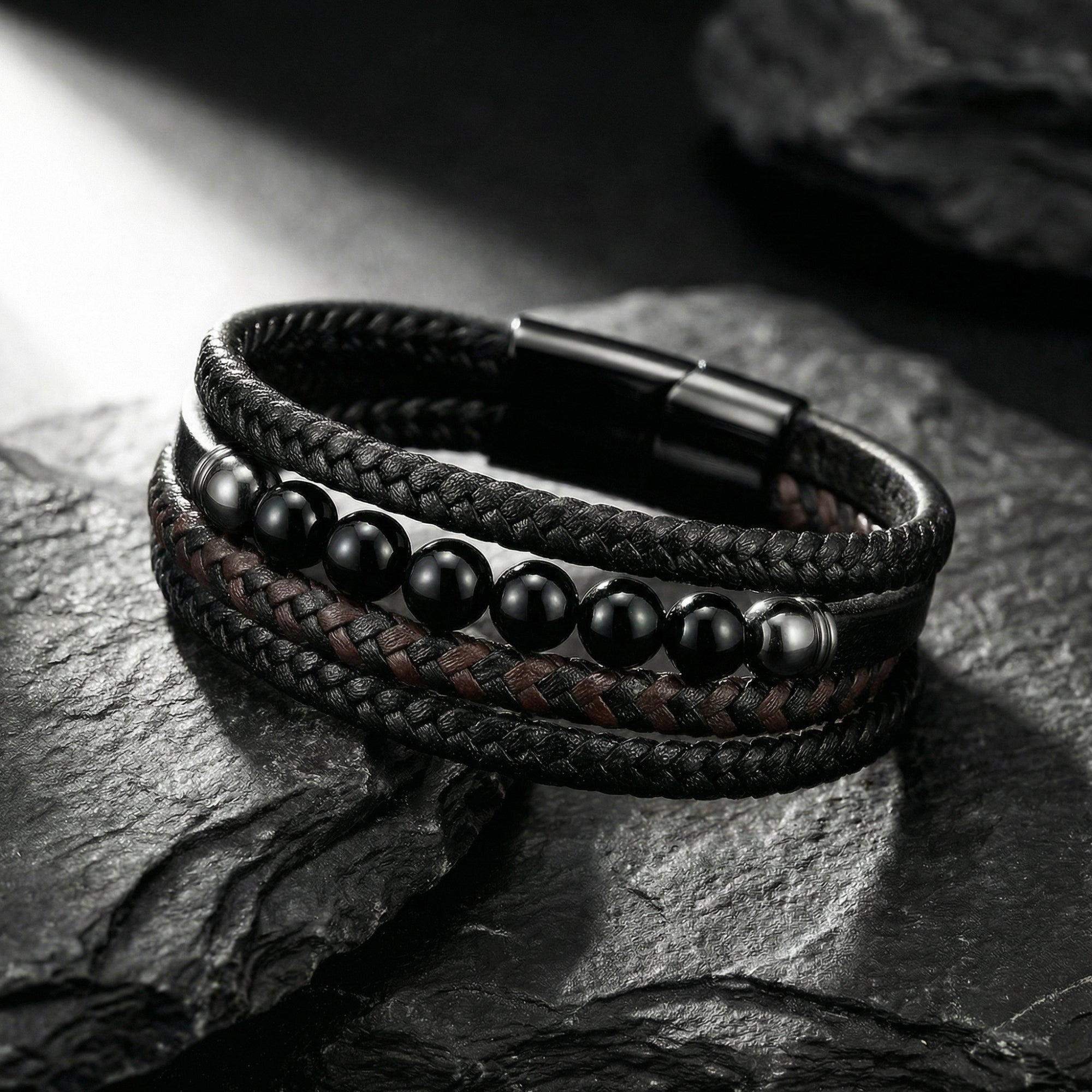 Close-up of a men's multi-strand leather bracelet with black beads and a black ion-bonded stainless steel clasp.