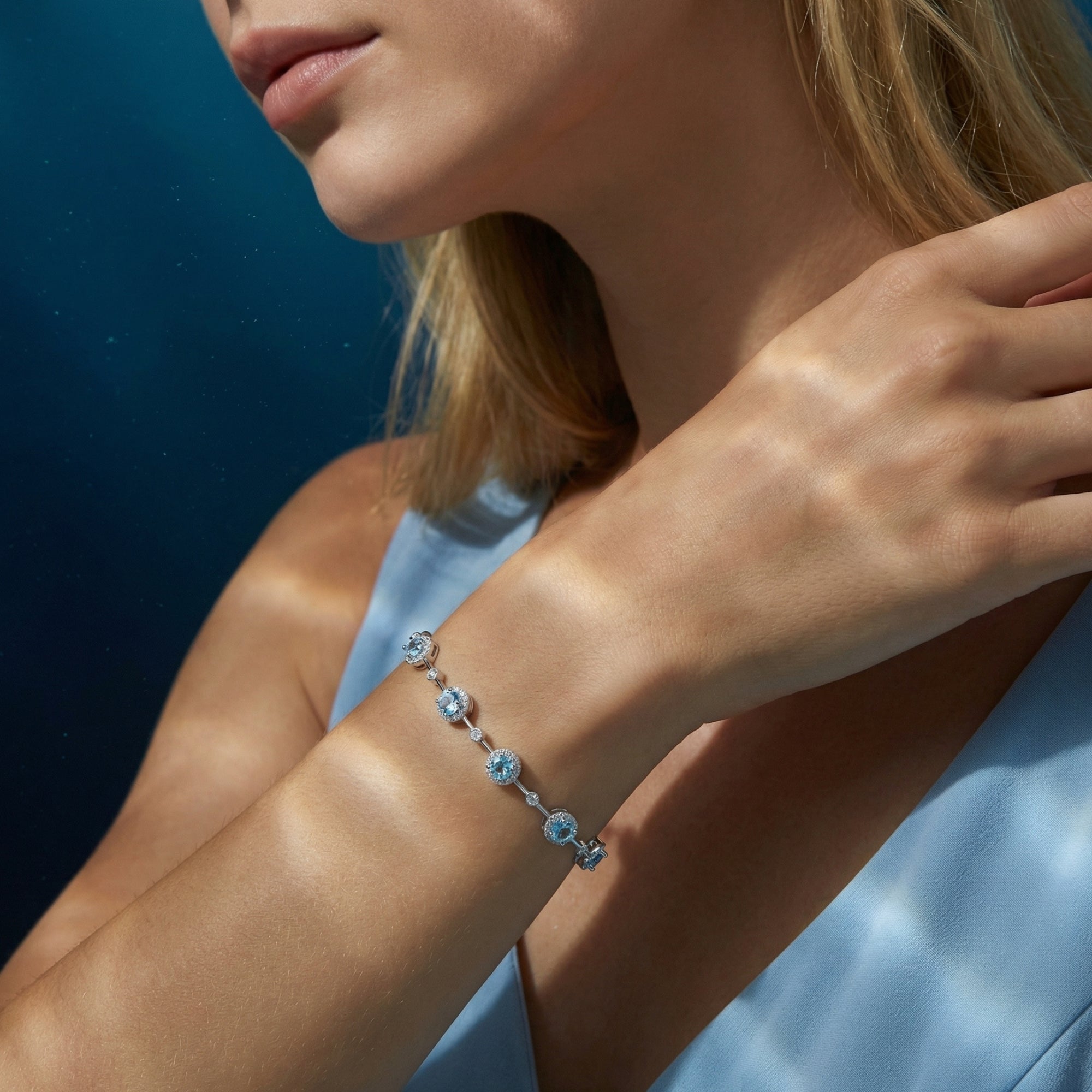 Close-up of the round aquamarine station bracelet in sterling silver on a model's wrist.