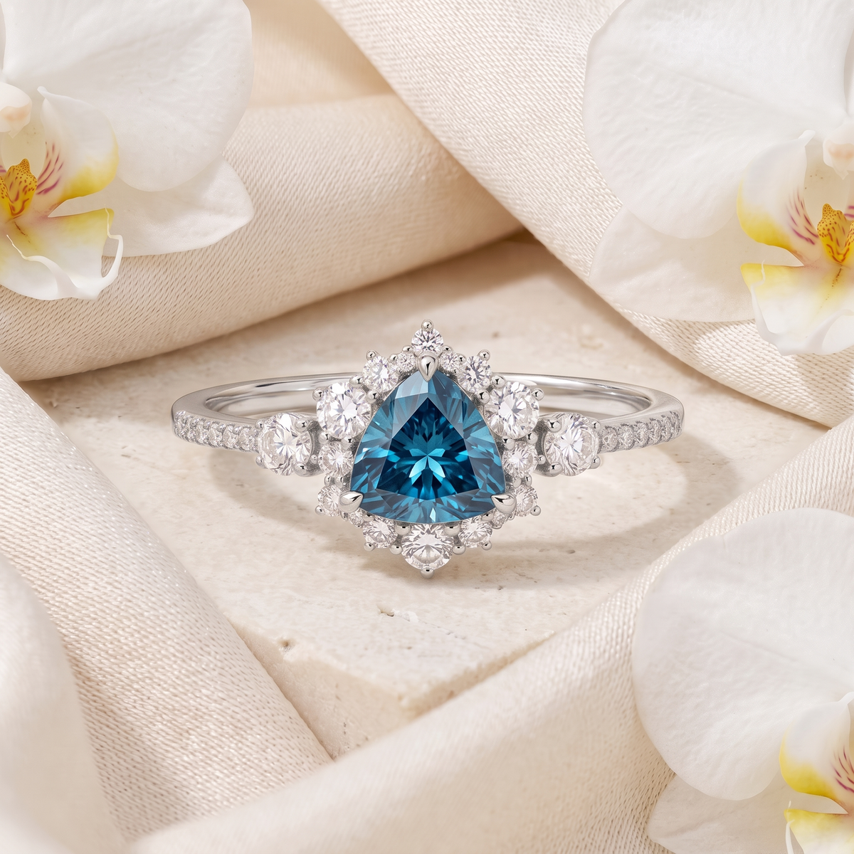 White gold halo ring featuring a central trillion-cut blue moissanite stone.