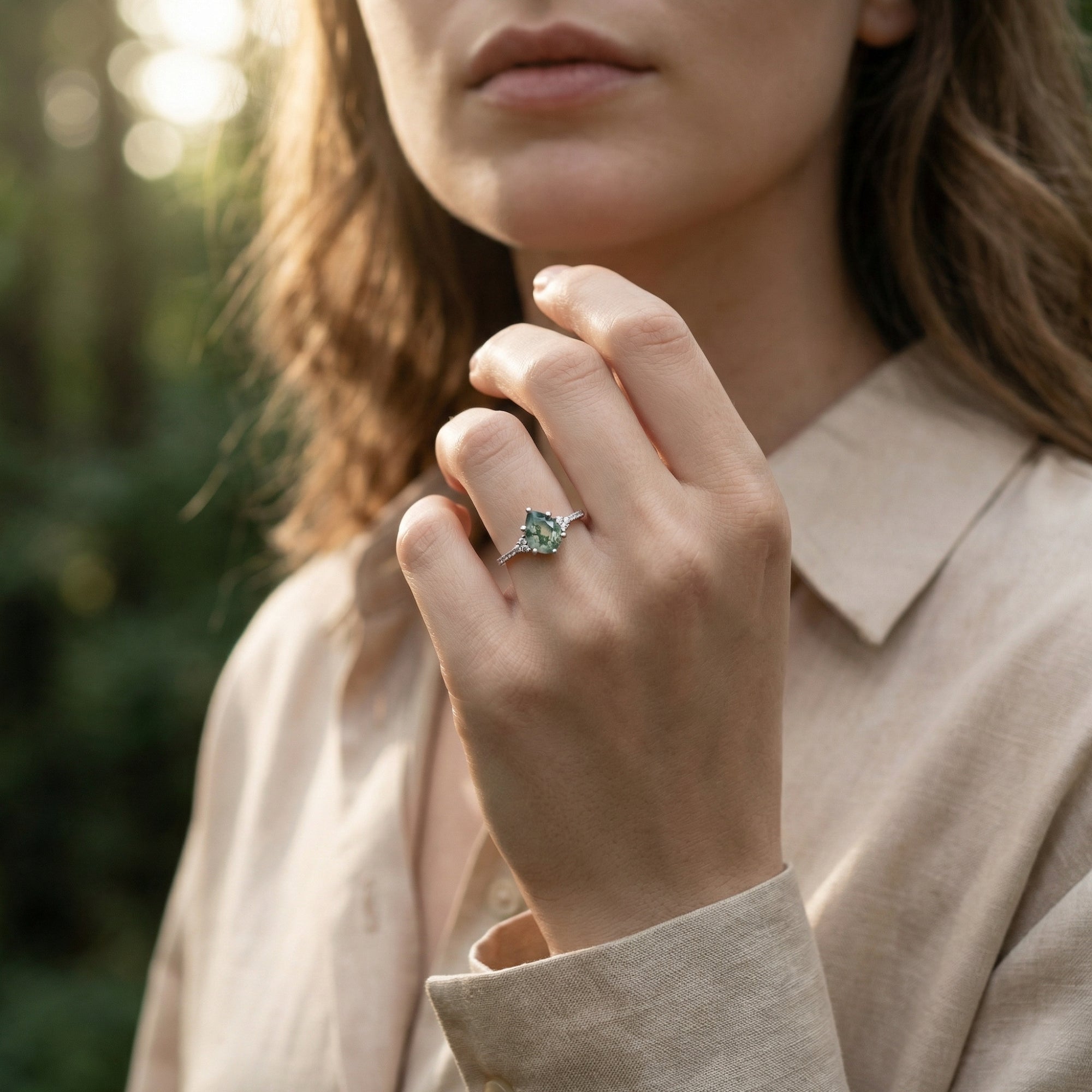Pear cut moss agate ring in S925 sterling silver worn on a woman's hand in natural outdoor light.