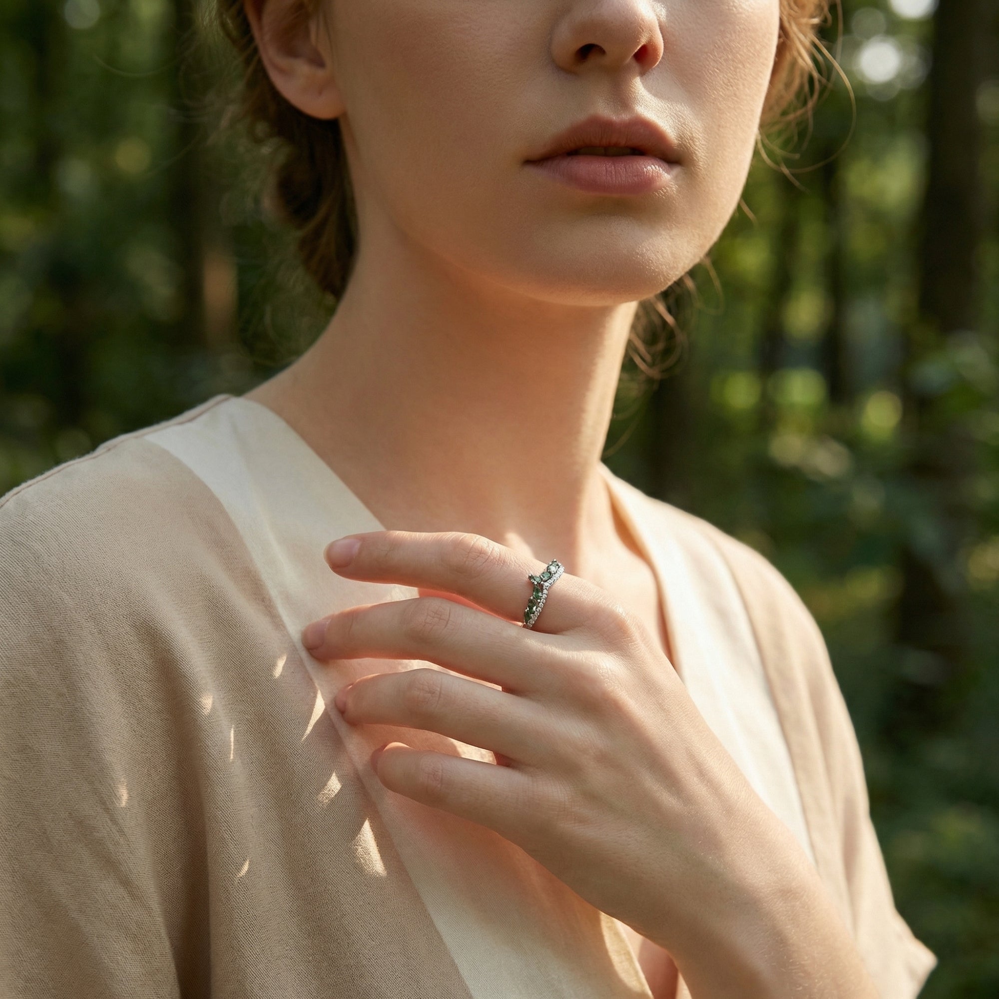 Sterling silver moss agate eternity wave ring worn by a model in a natural outdoor forest setting.