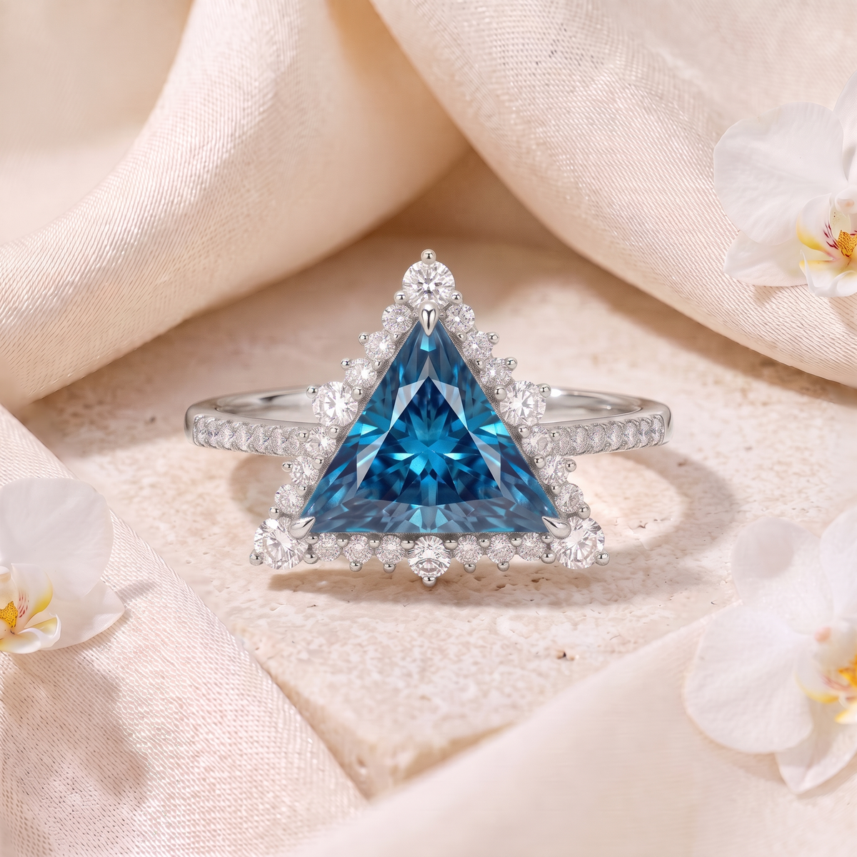 White gold trillion-cut blue moissanite engagement ring with diamond halo and pavé band