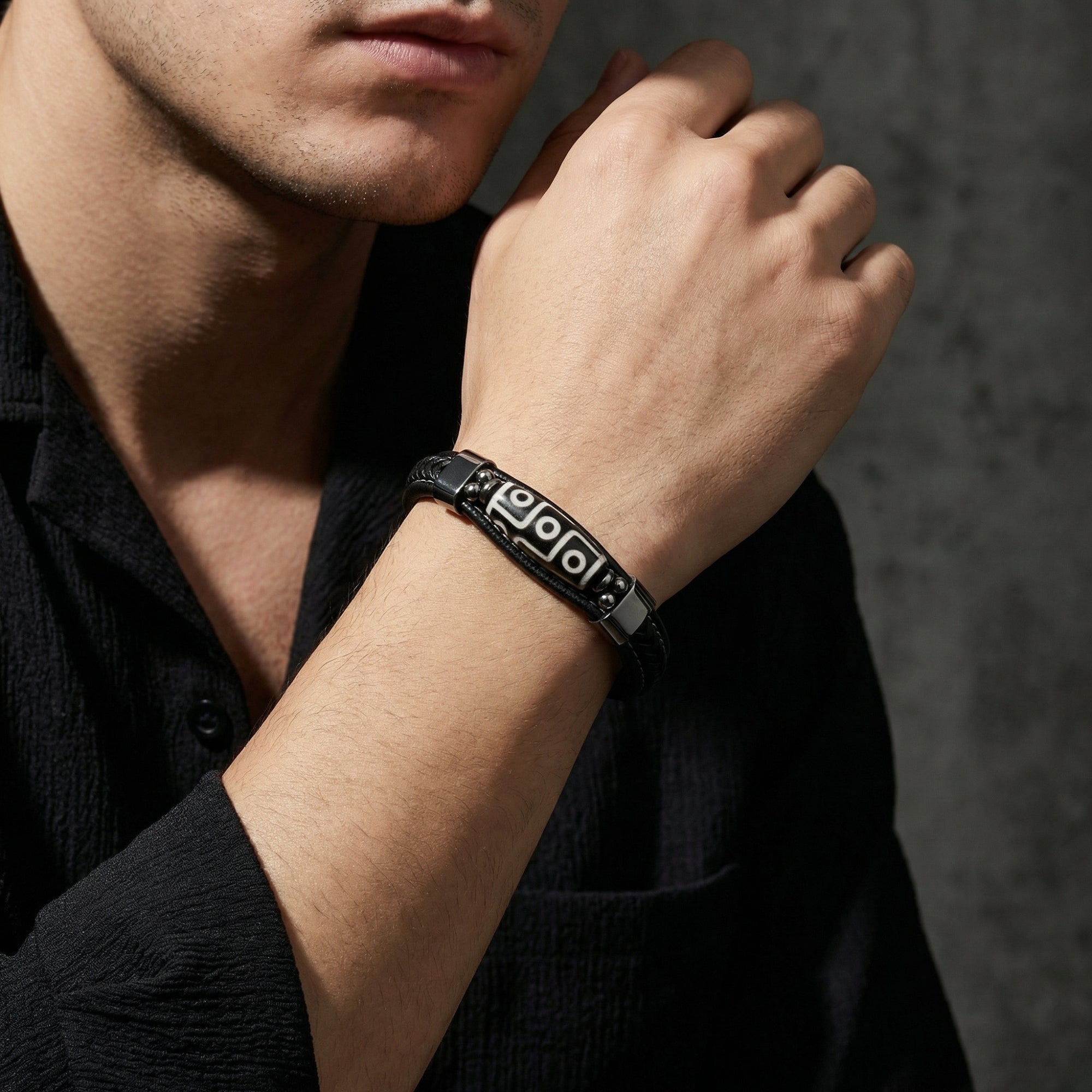 Side view of a man wearing the black leather Steadfast Bracelet with silver-tone 316L stainless steel hardware.