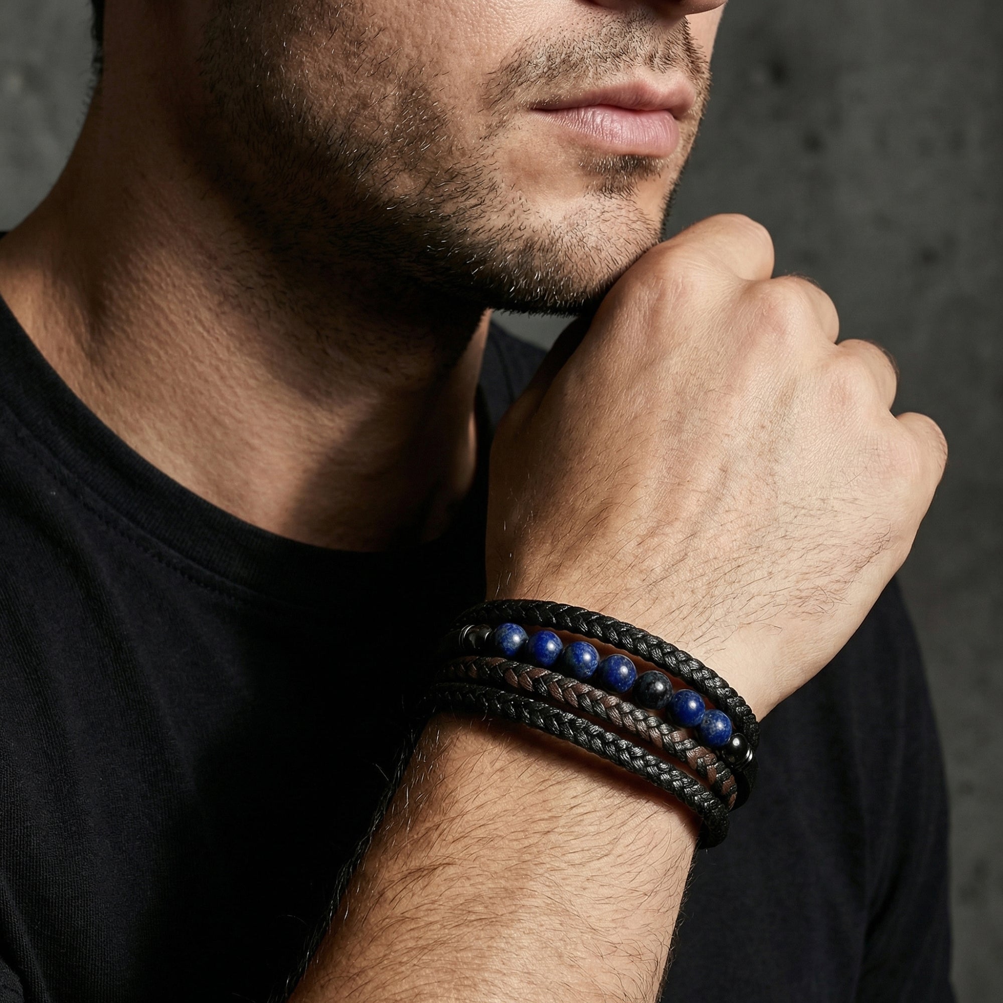 Masculine black leather wrap bracelet with blue stone beads styled on a man's wrist.