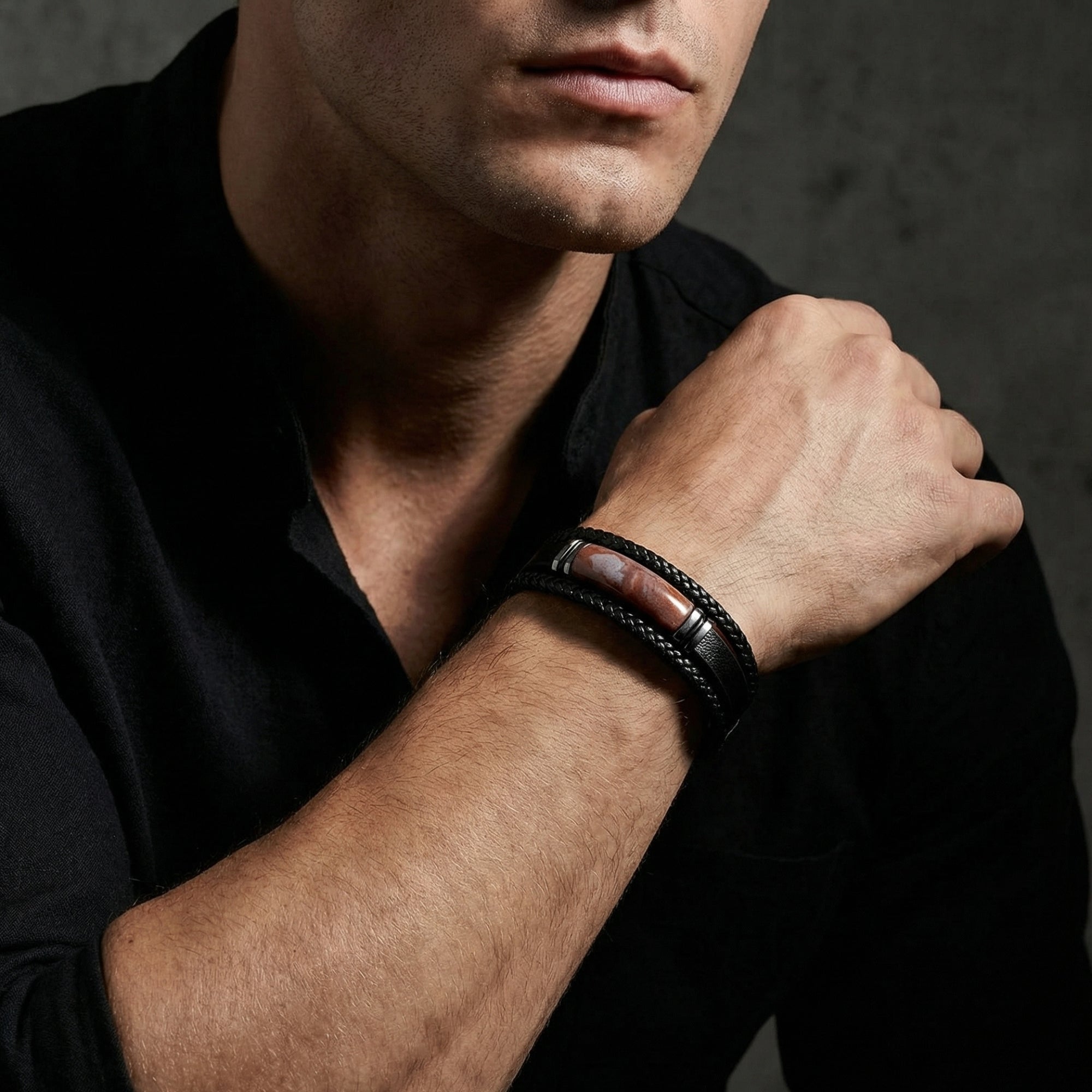 Model wearing the Apex black braided leather bracelet with a red stone inlay and black stainless steel.