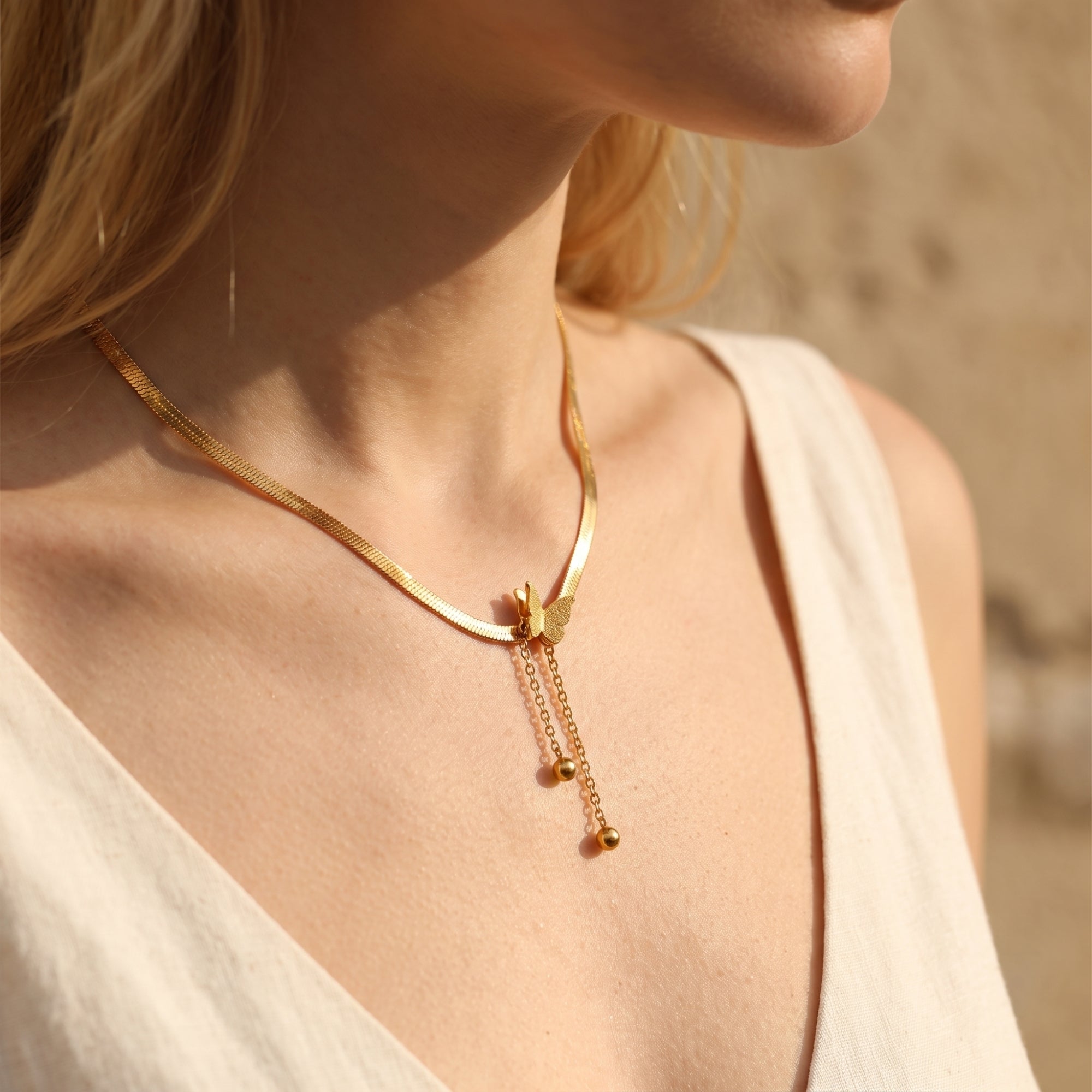 Le collier à pampilles et pendentif papillon