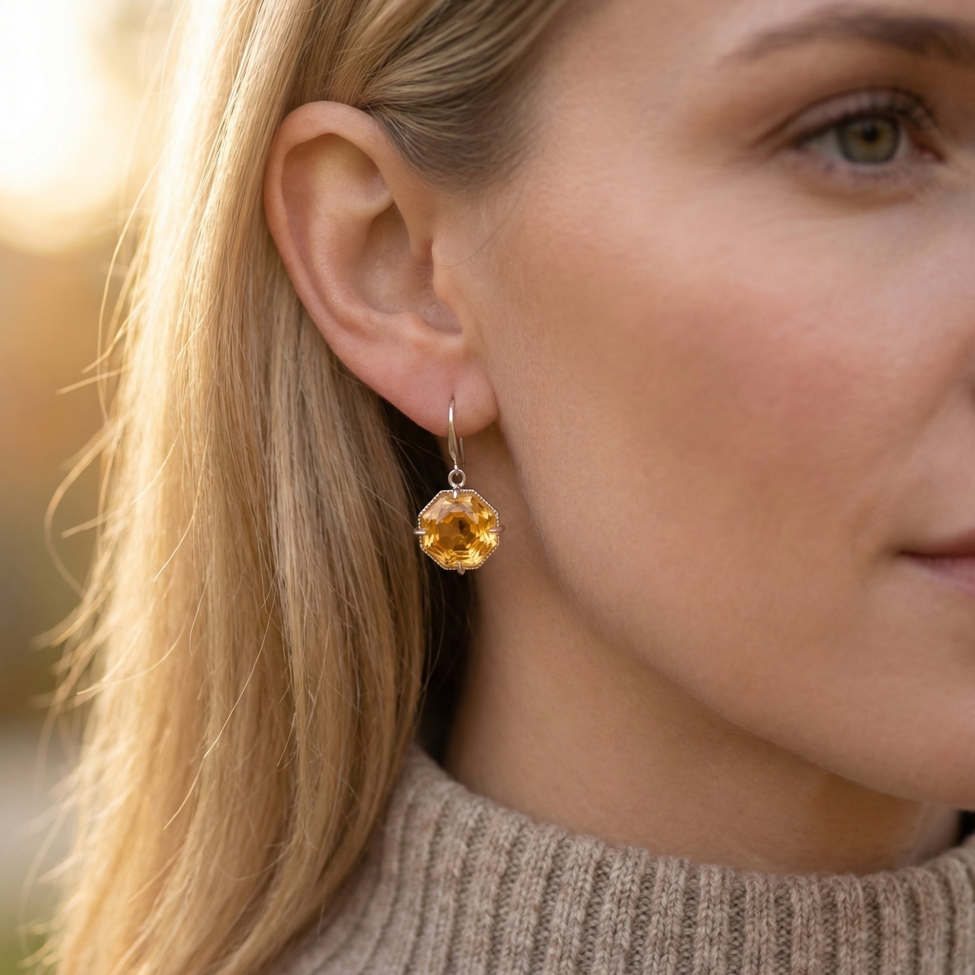 Side profile of a model wearing the Cyra natural citrine drop earrings in silver for a November birthstone gift.