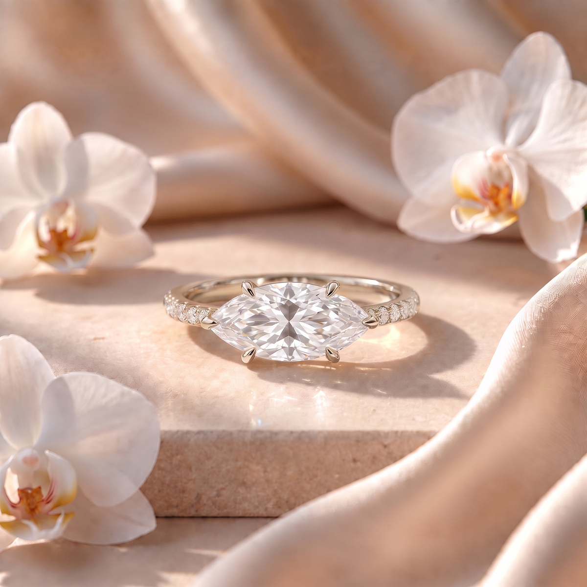 An east-west marquise moissanite engagement ring with a pavé band in white gold.