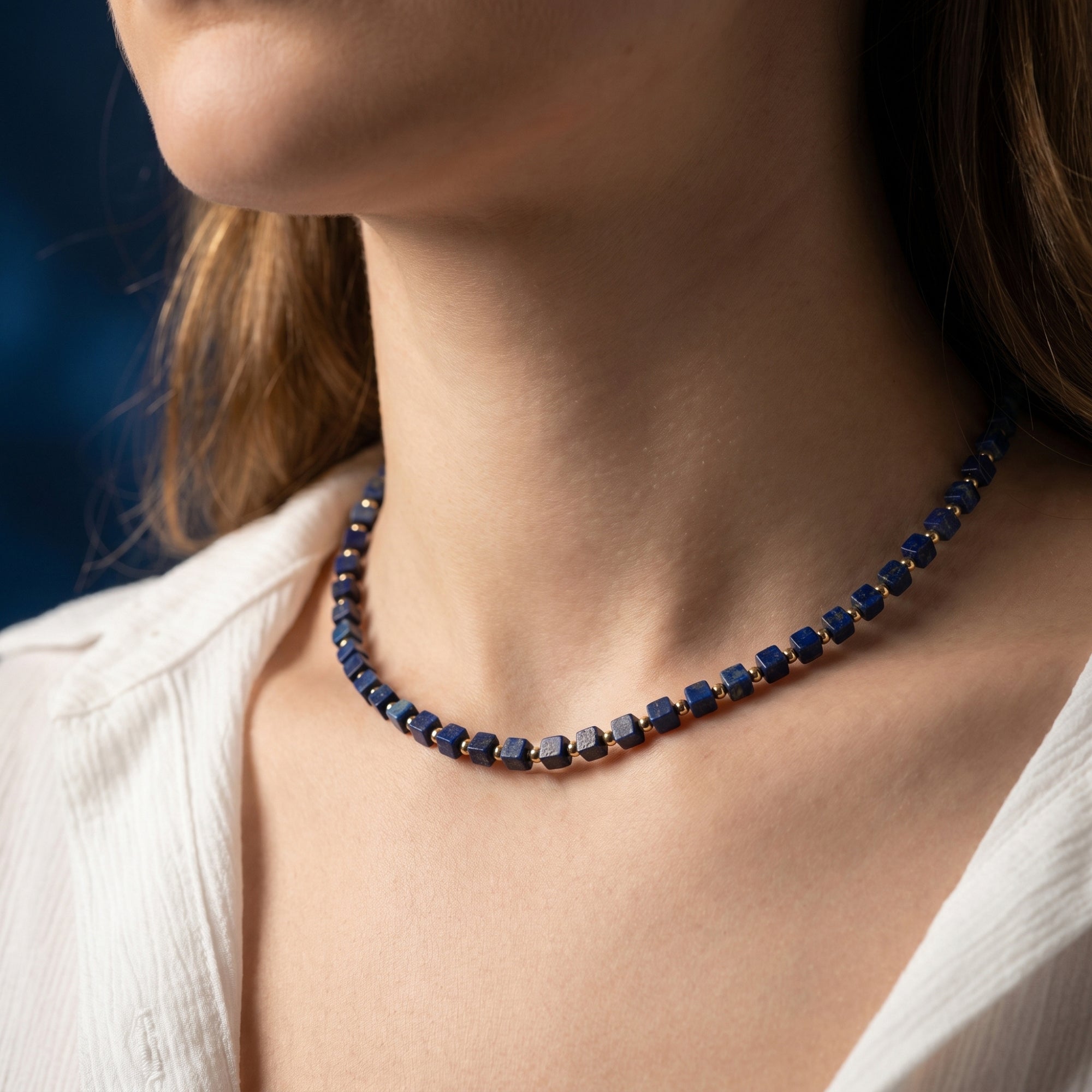 Sovereign Square natural lapis lazuli beaded necklace with gold-plated stainless steel worn by a model.