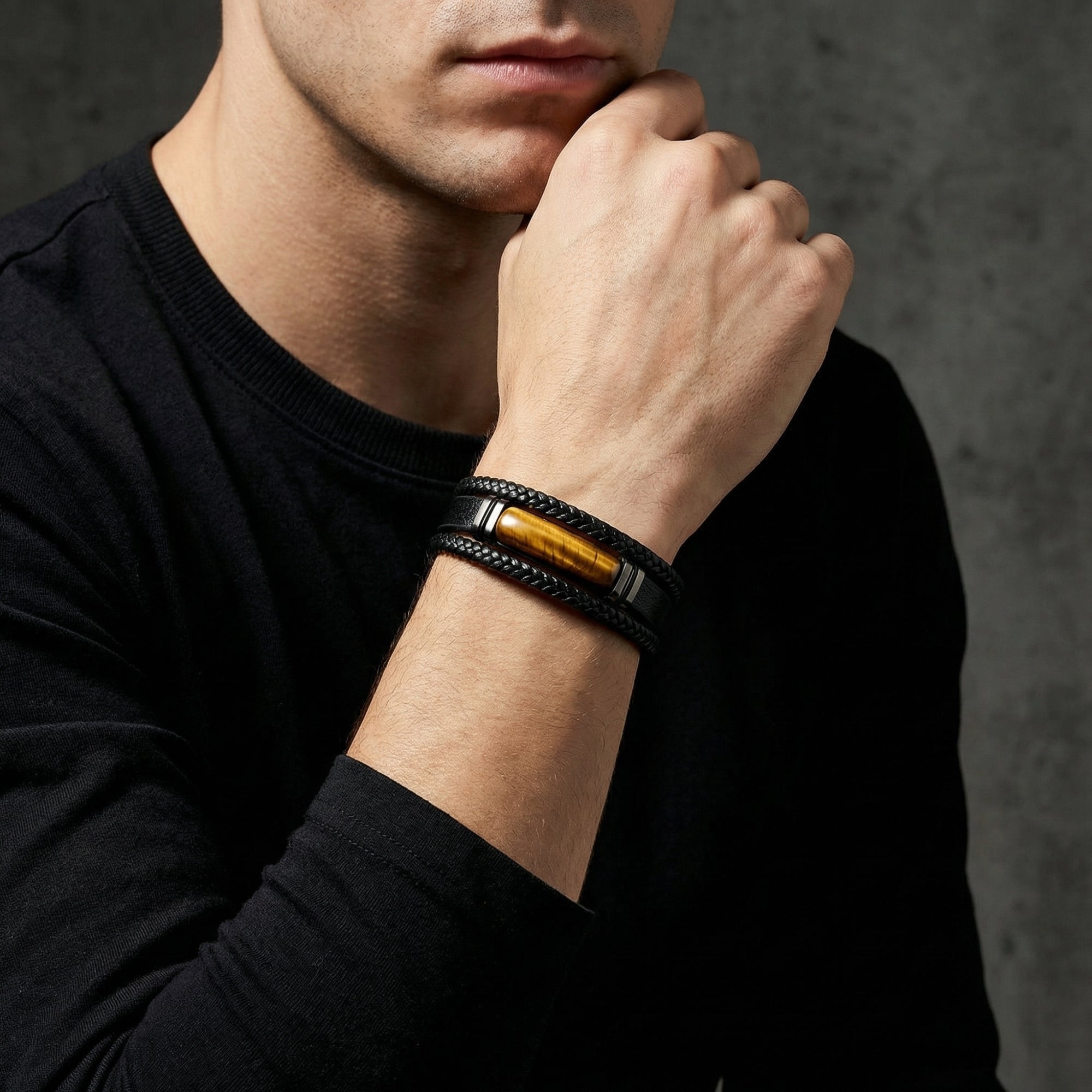 Model wearing the black braided leather bracelet with tiger's eye stone and black steel accents on his wrist.