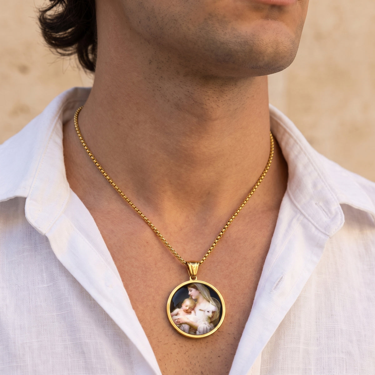 Man wearing the gold-tone Madonna and Child medallion necklace over an open white collared shirt.