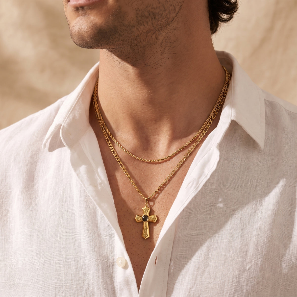 Man wearing the gold-tone layered cross necklace with an open-collar white shirt.
