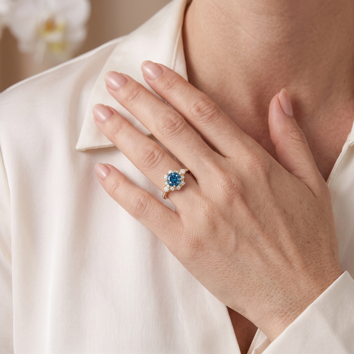 Close-up of a hand wearing the yellow gold blue moissanite cluster halo ring.