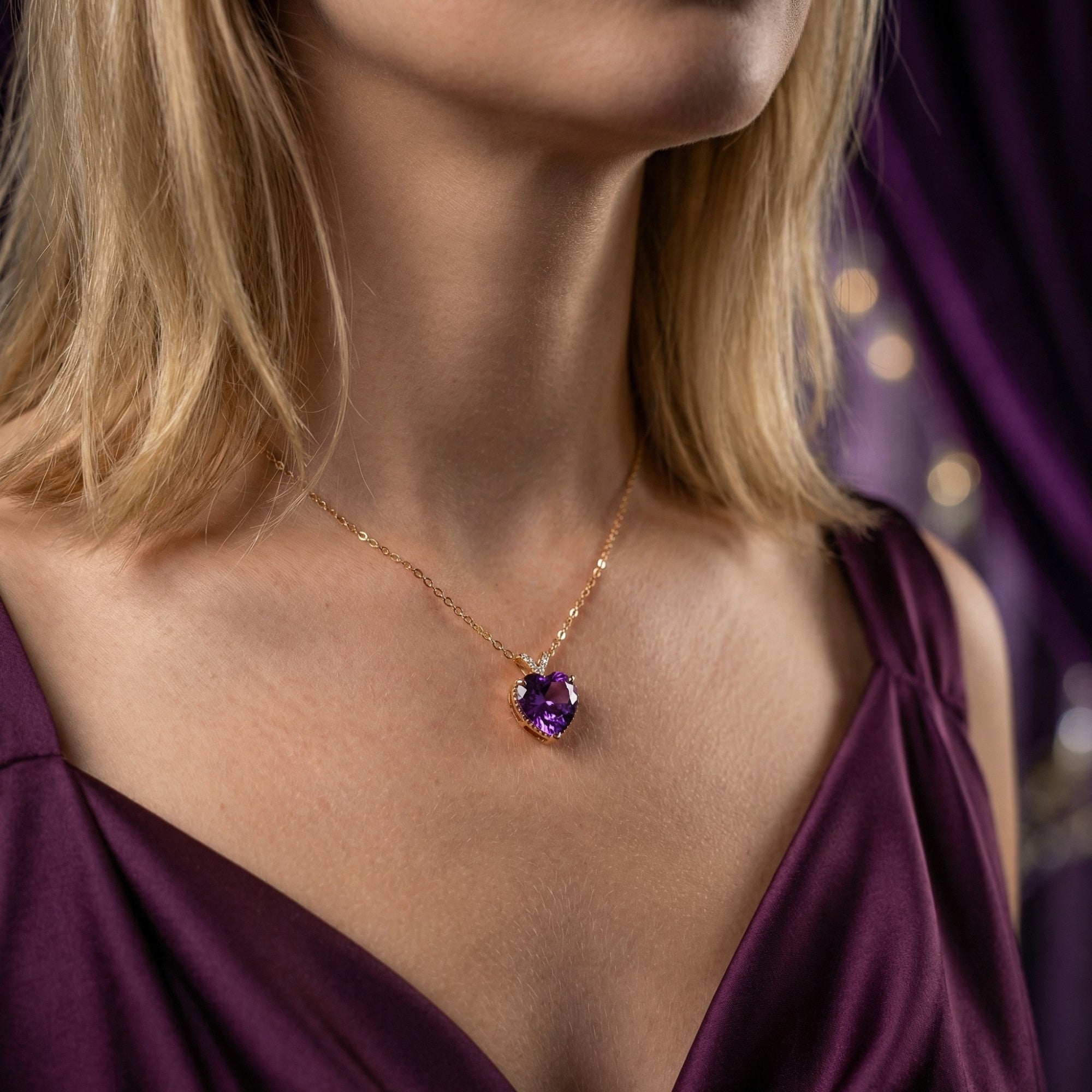 Heart-cut natural amethyst necklace in 18K rose gold worn by a model in a purple dress.