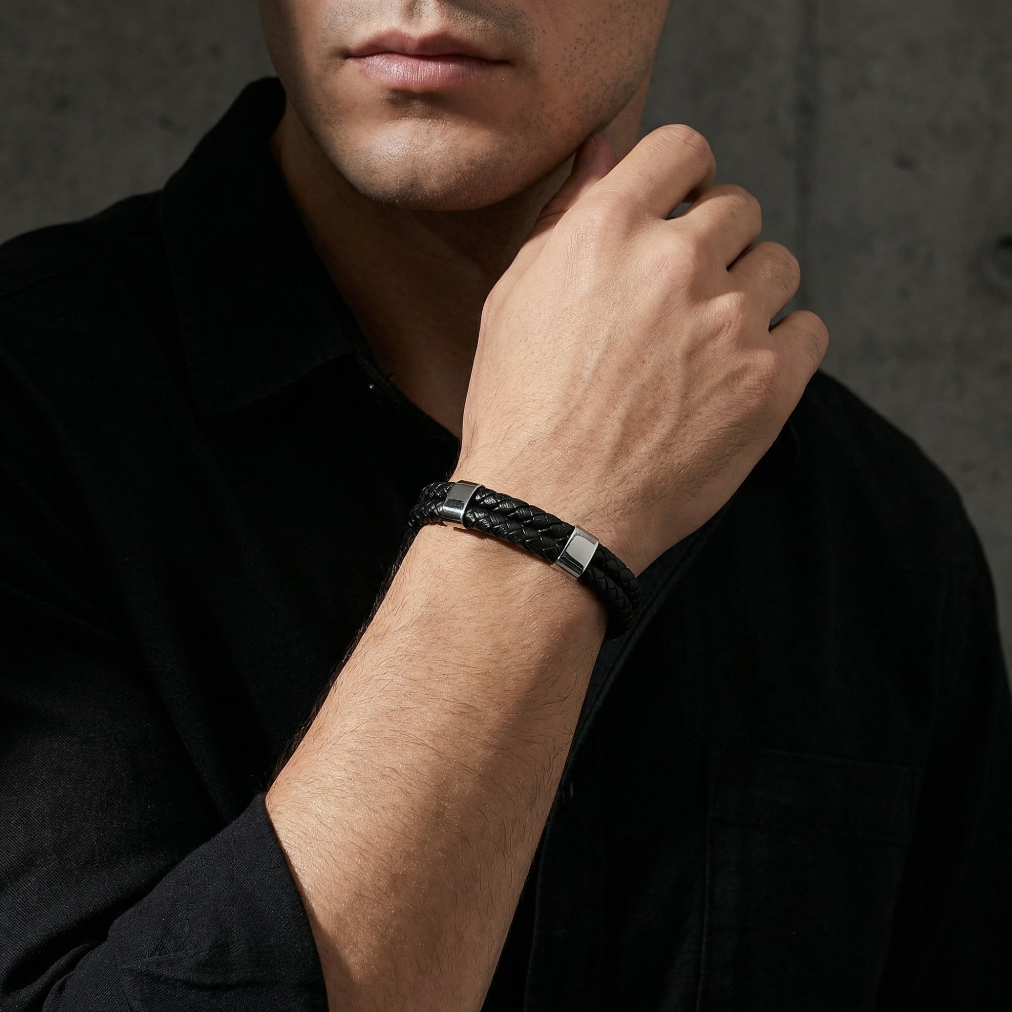 The Sentinel black leather bracelet with silver stainless steel hardware shown on a man's wrist.