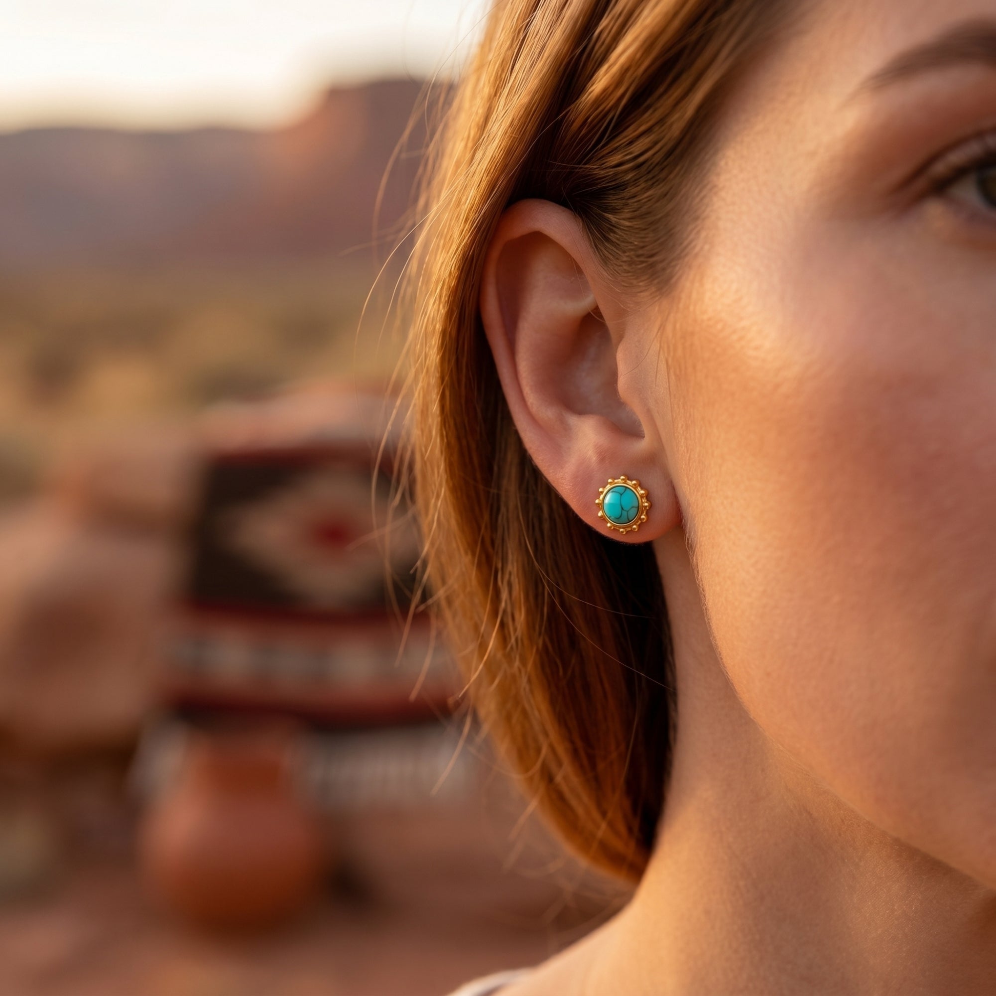 Southwestern boho gold turquoise stud earring worn by a model in a scenic desert environment.