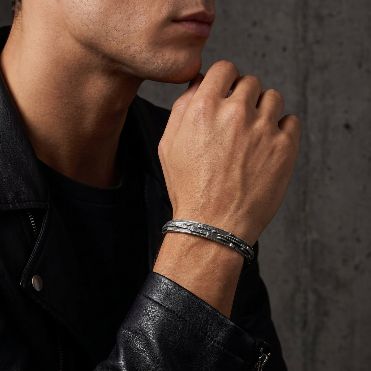 Model wearing the textured silver open cuff bracelet with a black leather jacket.