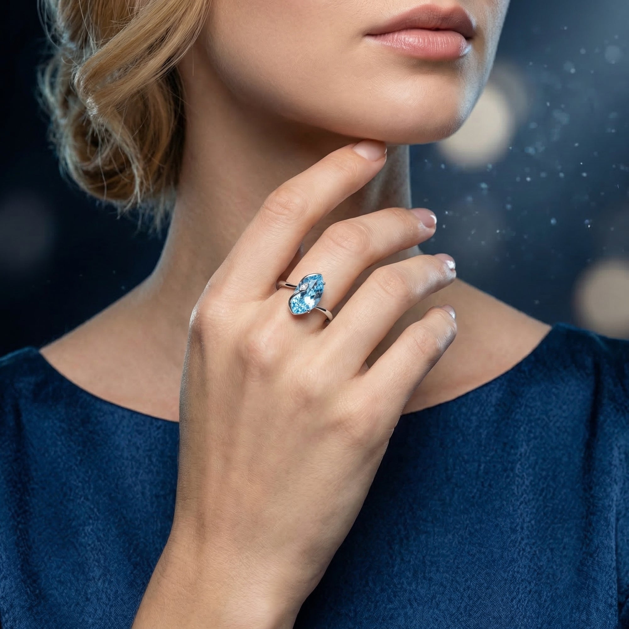 Woman wearing the marquise cut natural blue topaz sterling silver ring with a navy blue dress.