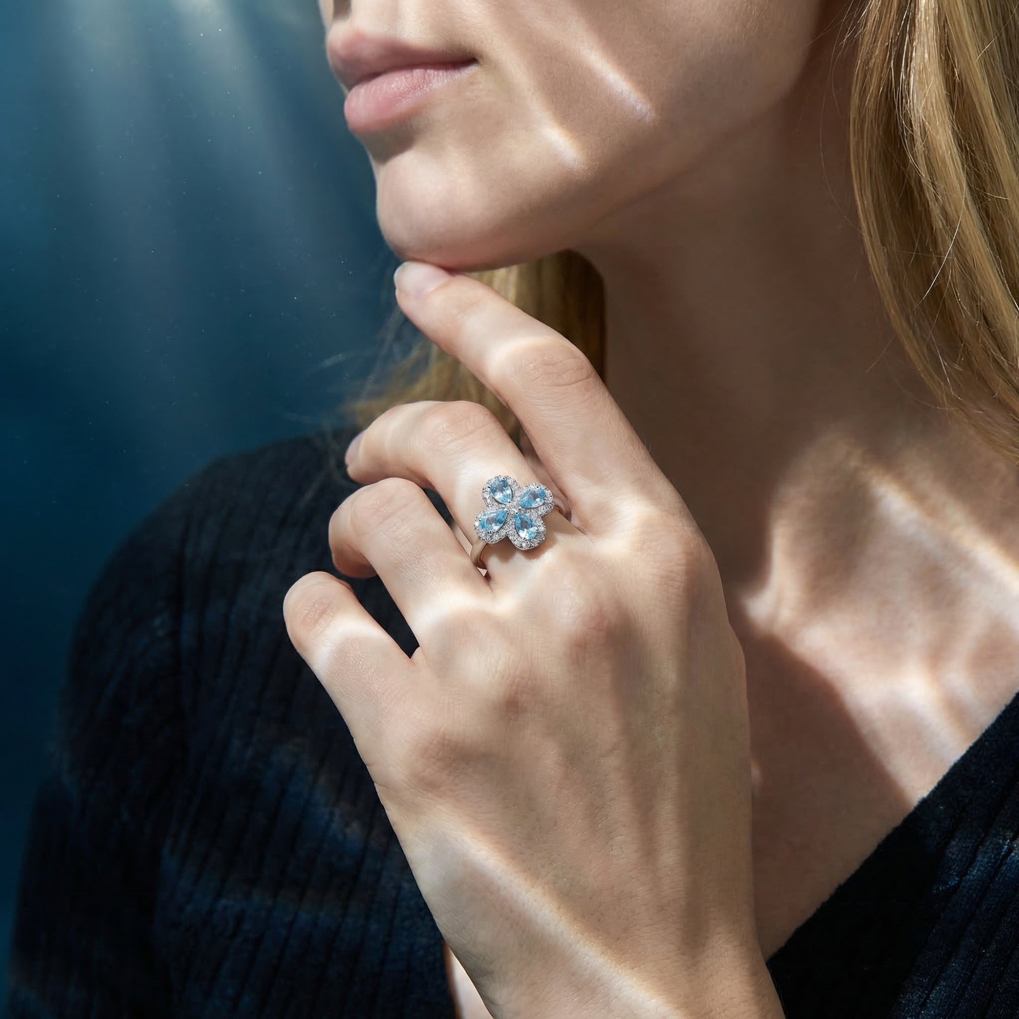 Model wearing the Azure Flora aquamarine ring in silver, showcasing the floral design on the hand.