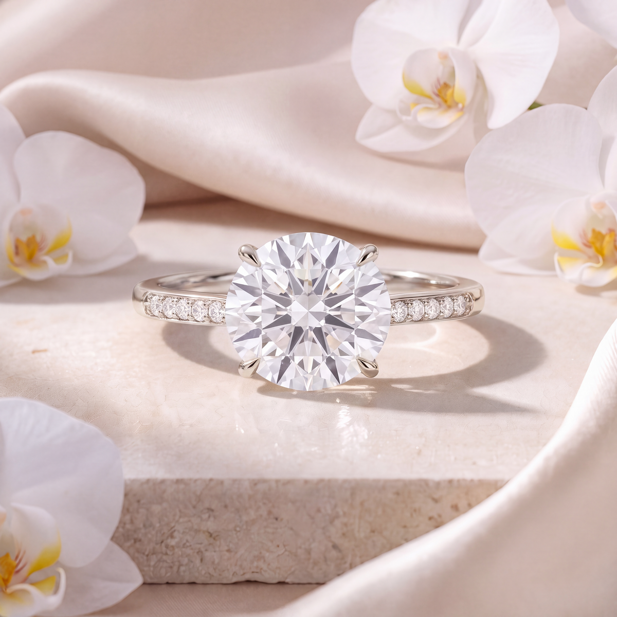 Front view of a round moissanite engagement ring in white gold with a pavé-set band.
