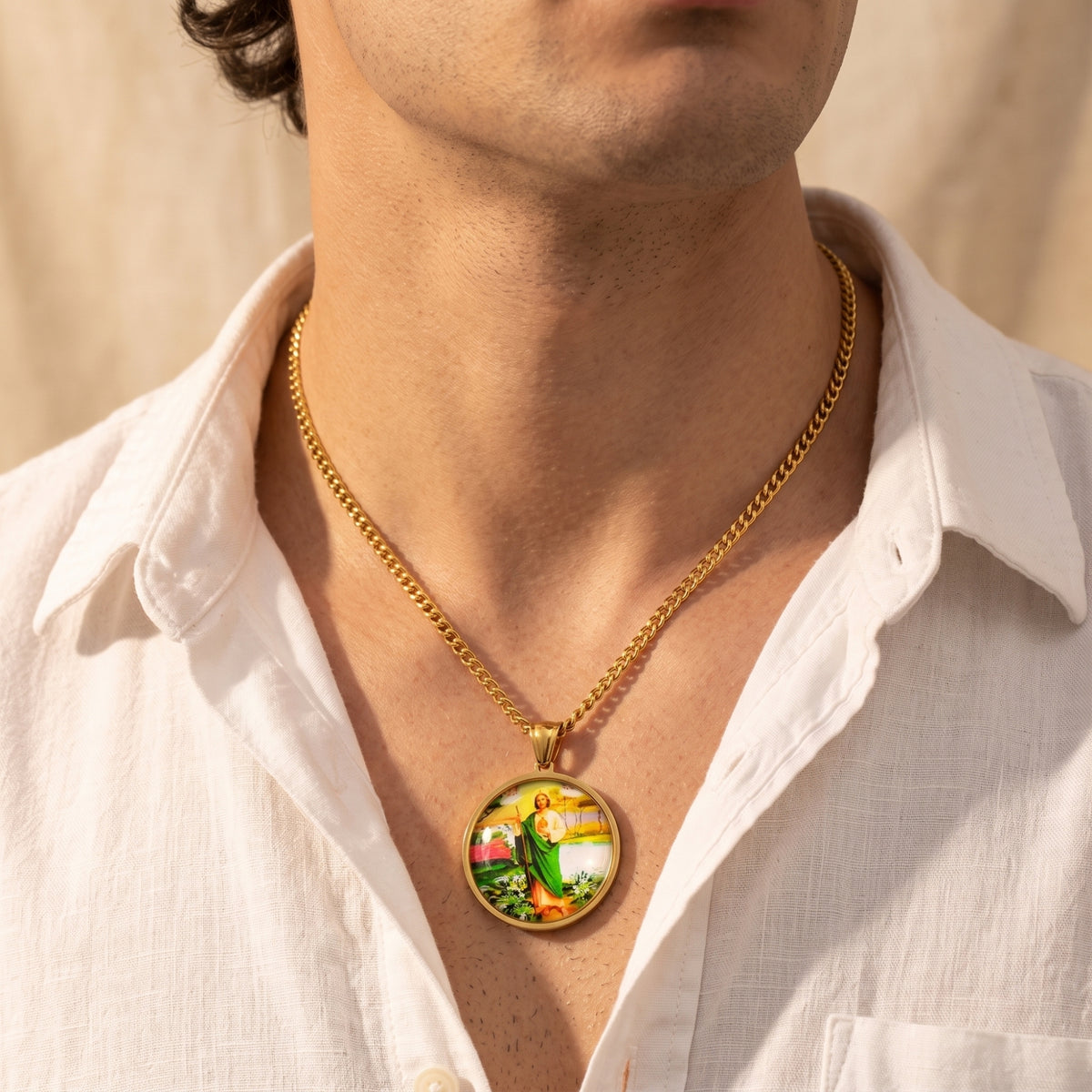 Man wearing the gold-tone St. Jude medallion necklace with an open white shirt.