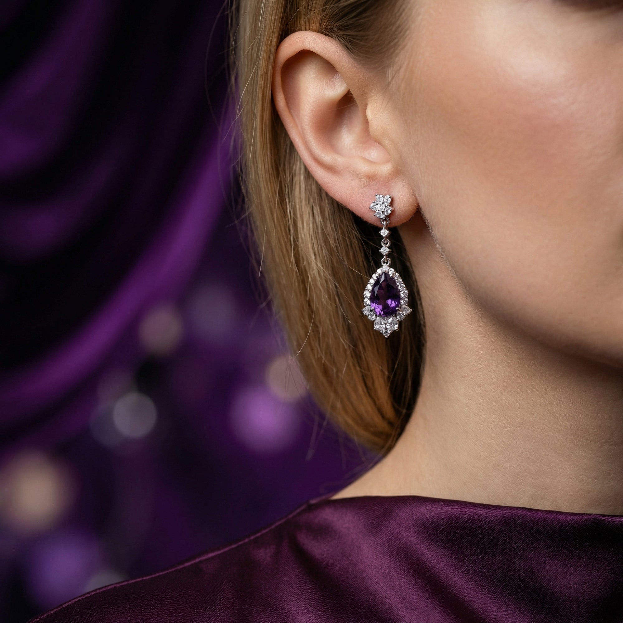 Side view of a pear cut natural amethyst drop earring in S925 sterling silver worn by a model.