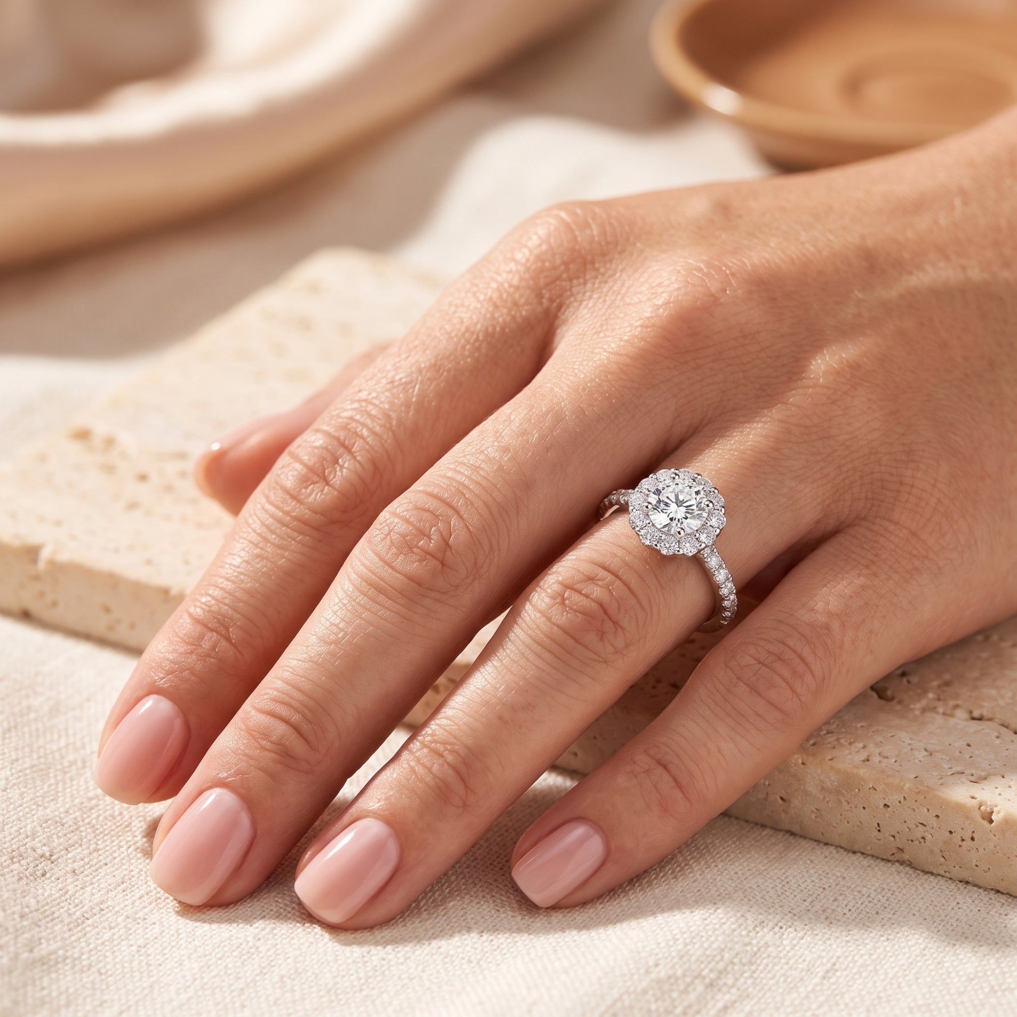 Woman's hand wearing the S925 silver floral halo promise ring, resting on a neutral stone background.