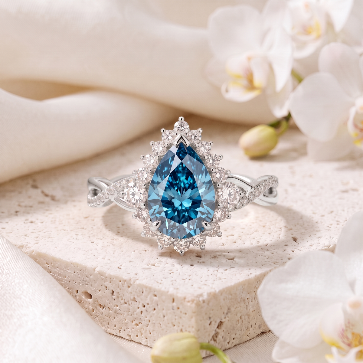 Pear cut blue moissanite halo engagement ring with an intertwined pave band in white gold.