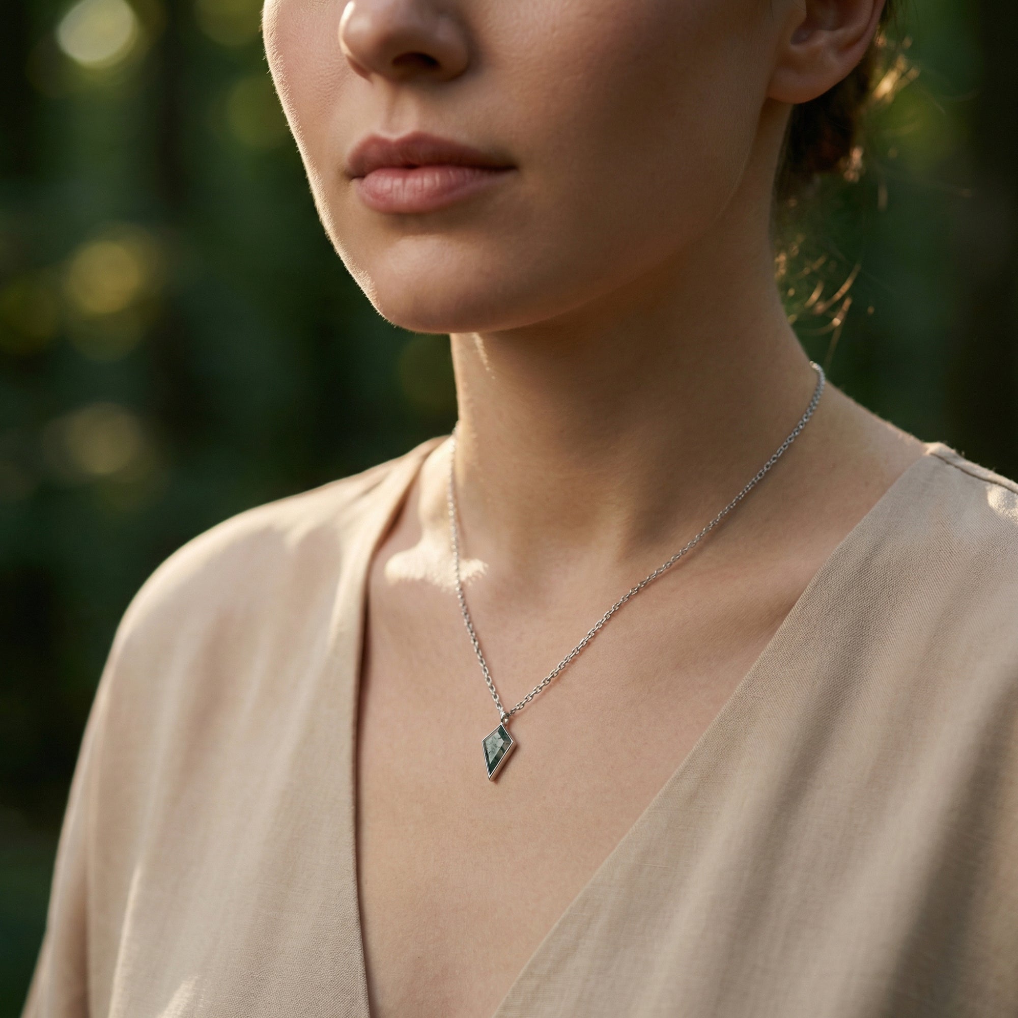 A model showcases the kite cut moss agate S925 sterling silver necklace, highlighting its elegant fit on the neck.