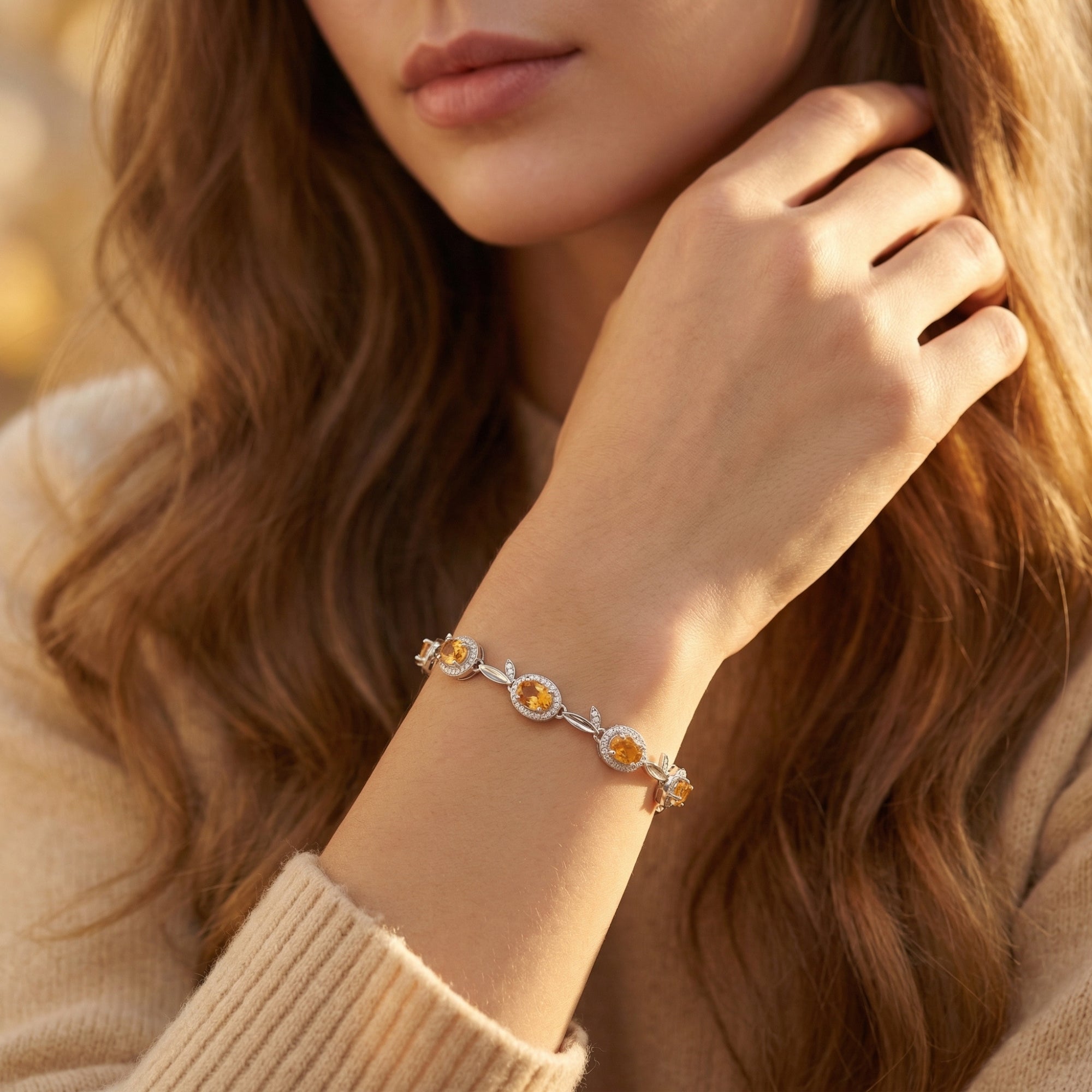 Close-up of a woman wearing the Sunniva silver bracelet with faceted oval citrine stones and sparkling zircon accents.